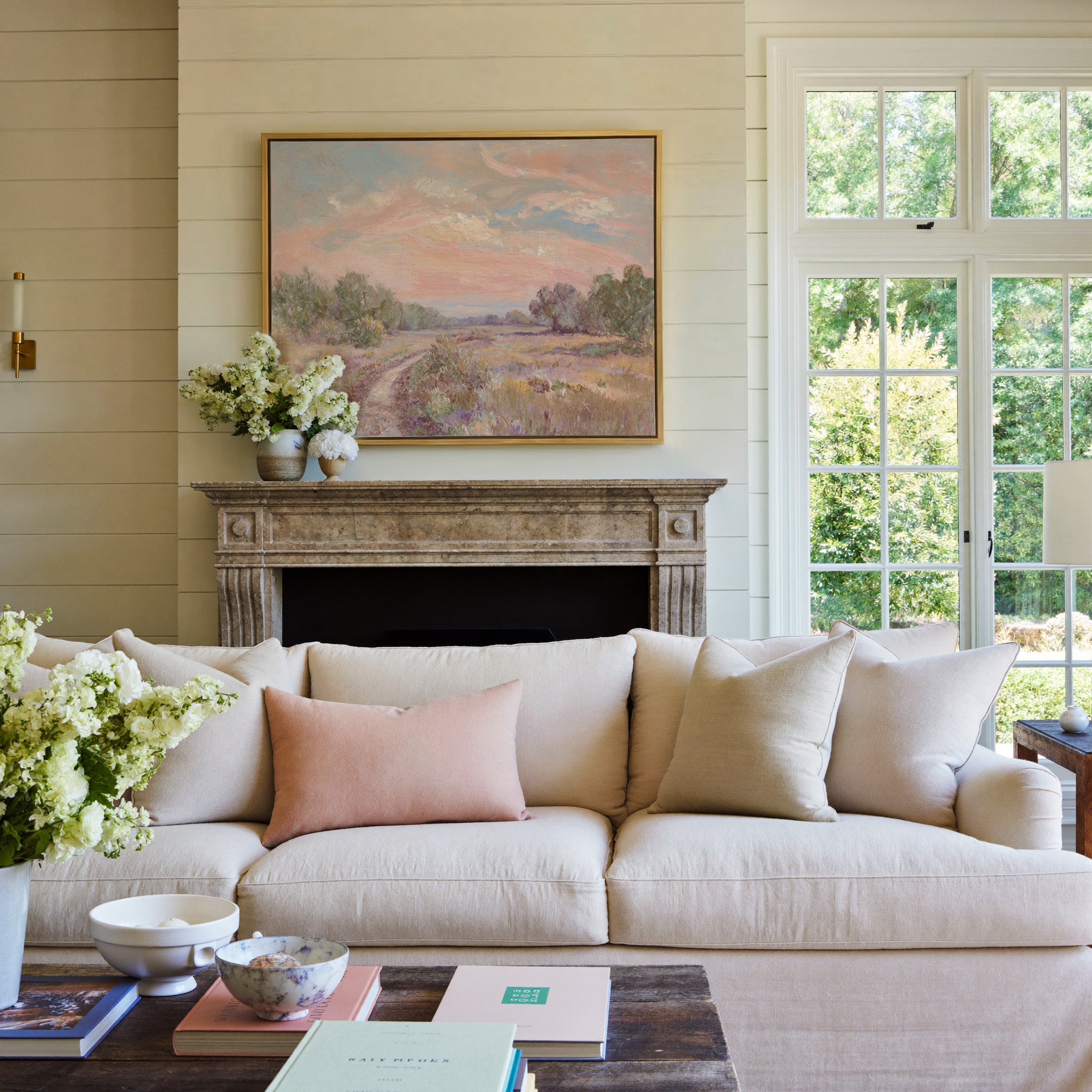 soft pink sky over a winding meadow path canvas wall art in a gold frame above a mantel