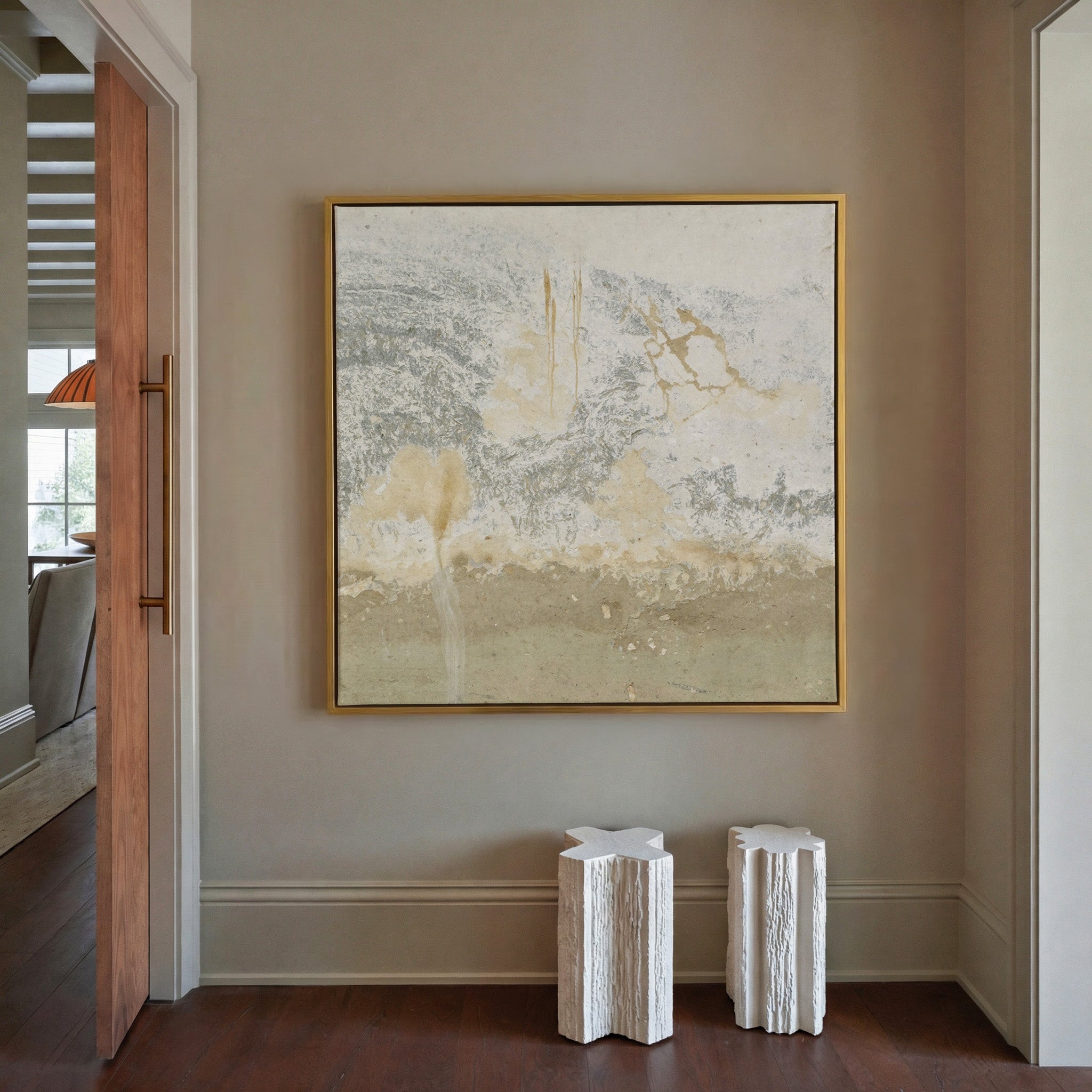 soft cream and taupe abstract with gray canvas wall art in a gold frame in a styled room setting