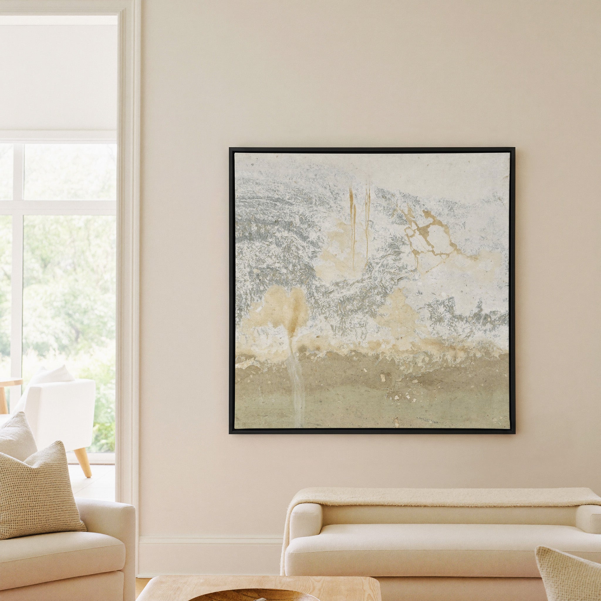 soft cream and taupe abstract with gray canvas wall art in a black frame in a living room