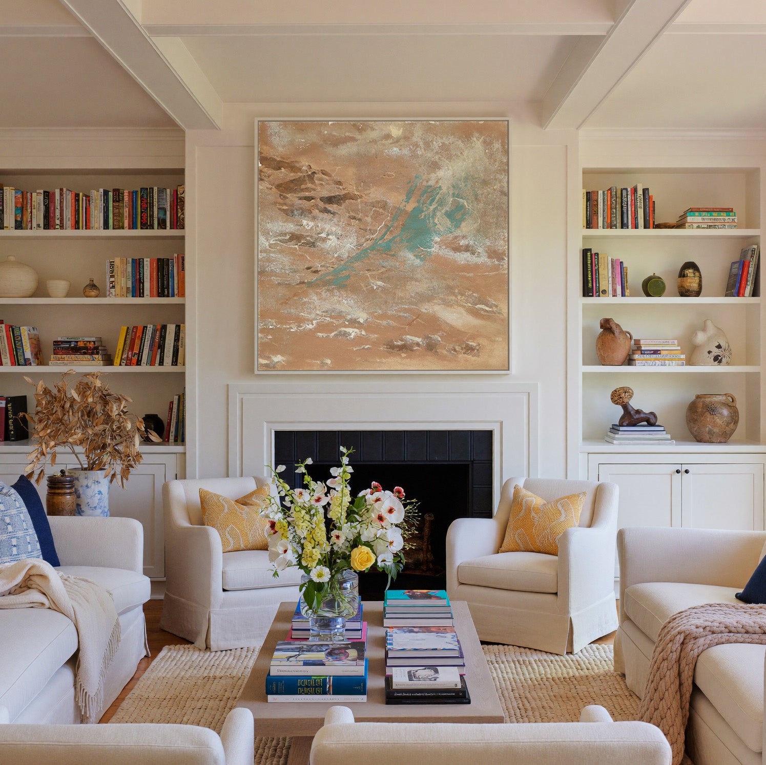 warm tan abstract with turquoise streaks and canvas wall art in a white frame above a fireplace