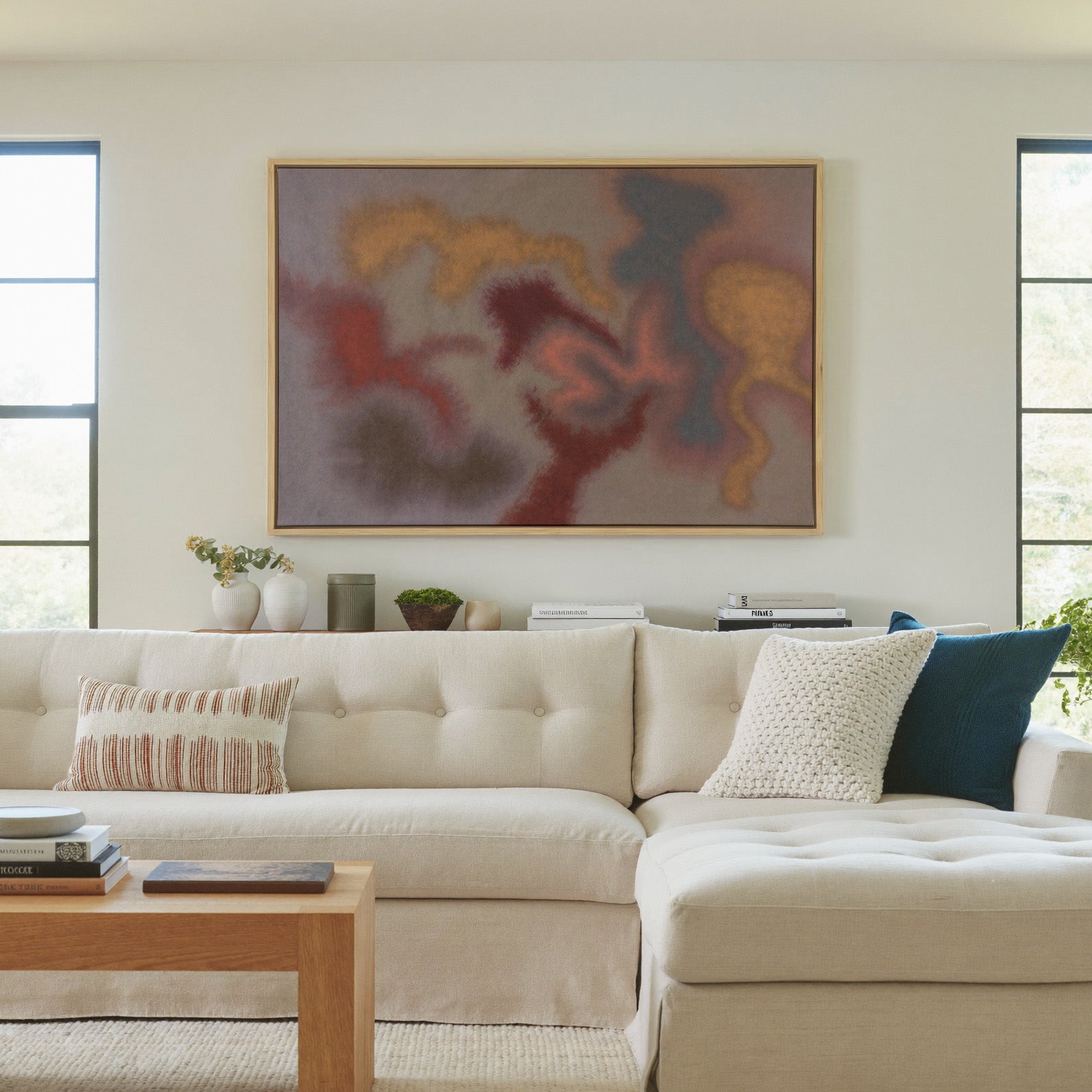 soft rust, gold, and slate abstract canvas wall art in a natural wood frame in a living room