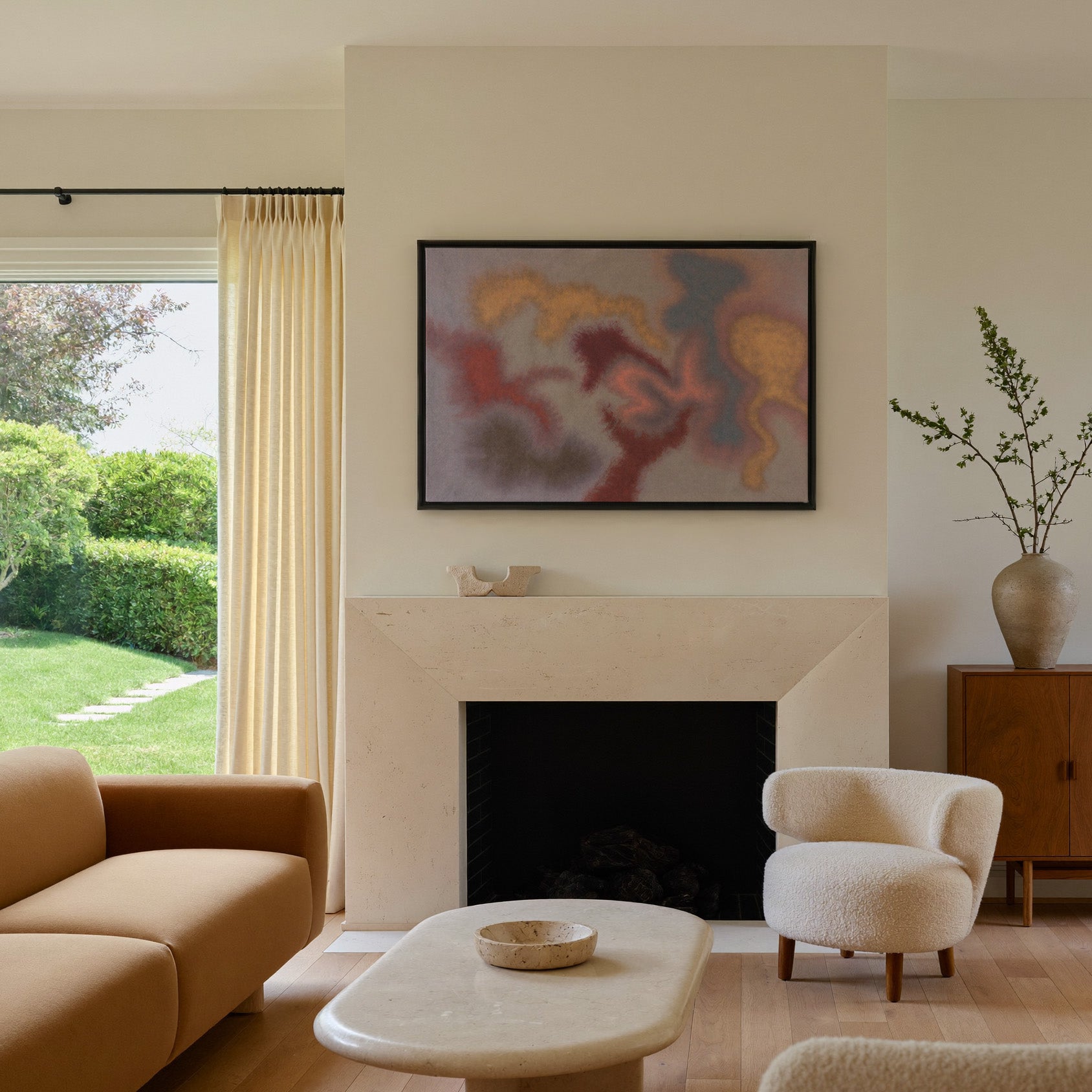 soft rust, gold, and slate abstract canvas wall art in a black frame above a mantel