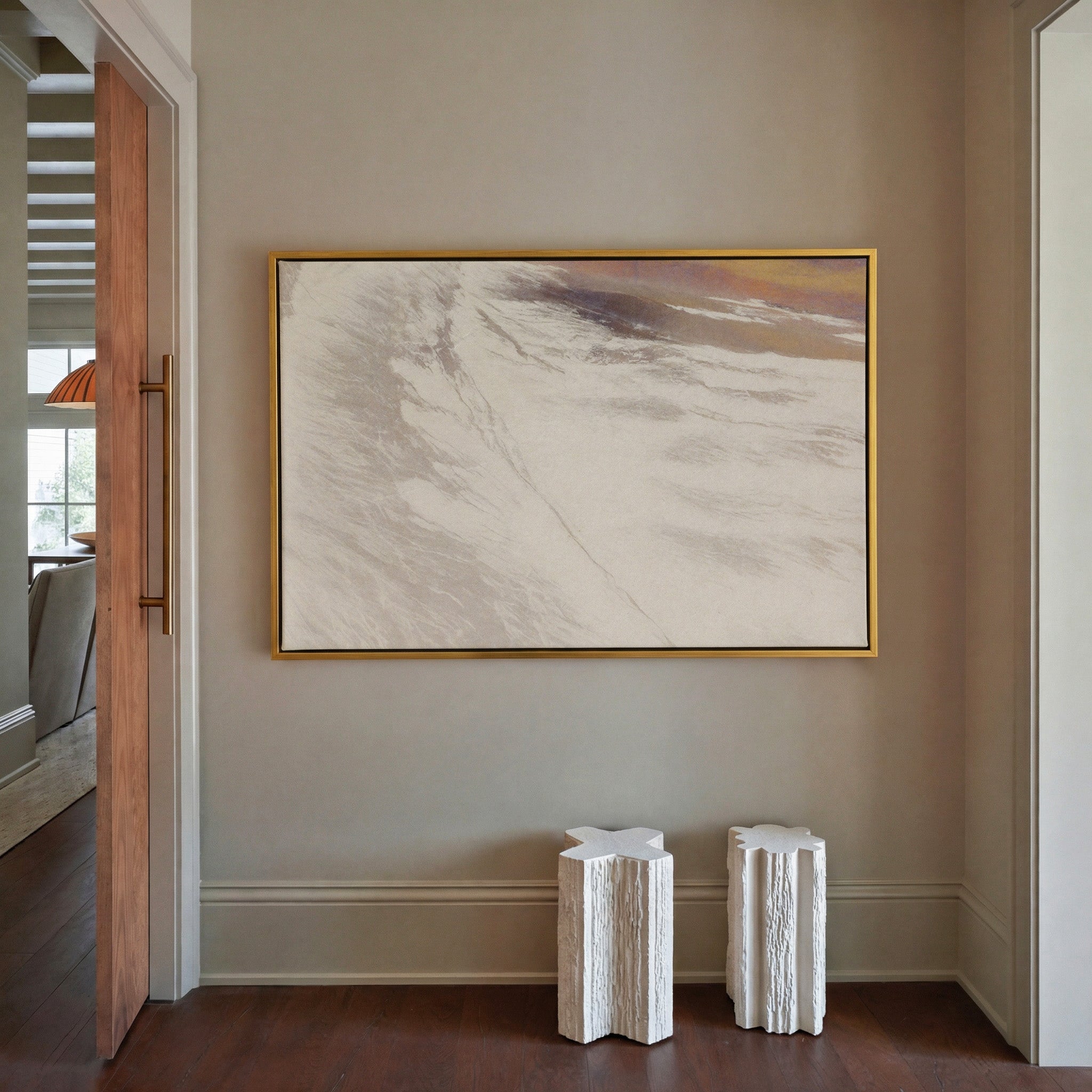 warm beige abstract with sweeping diagonal canvas wall art in a gold frame in a styled room setting