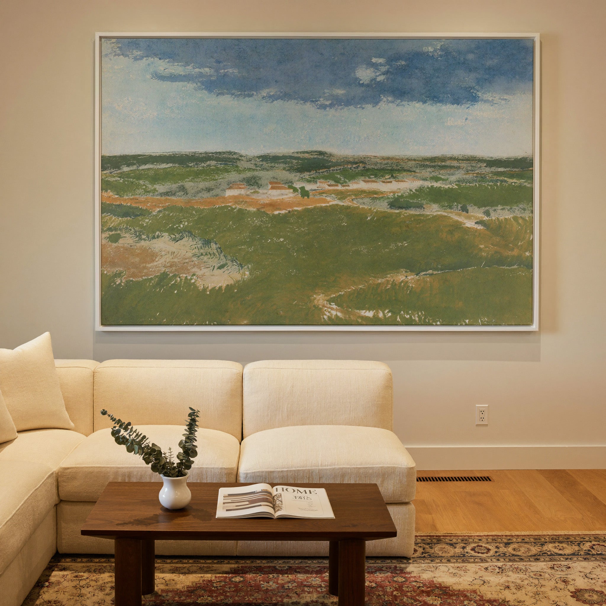 green dunes under a broad blue sky canvas wall art in a white frame in a styled room setting
