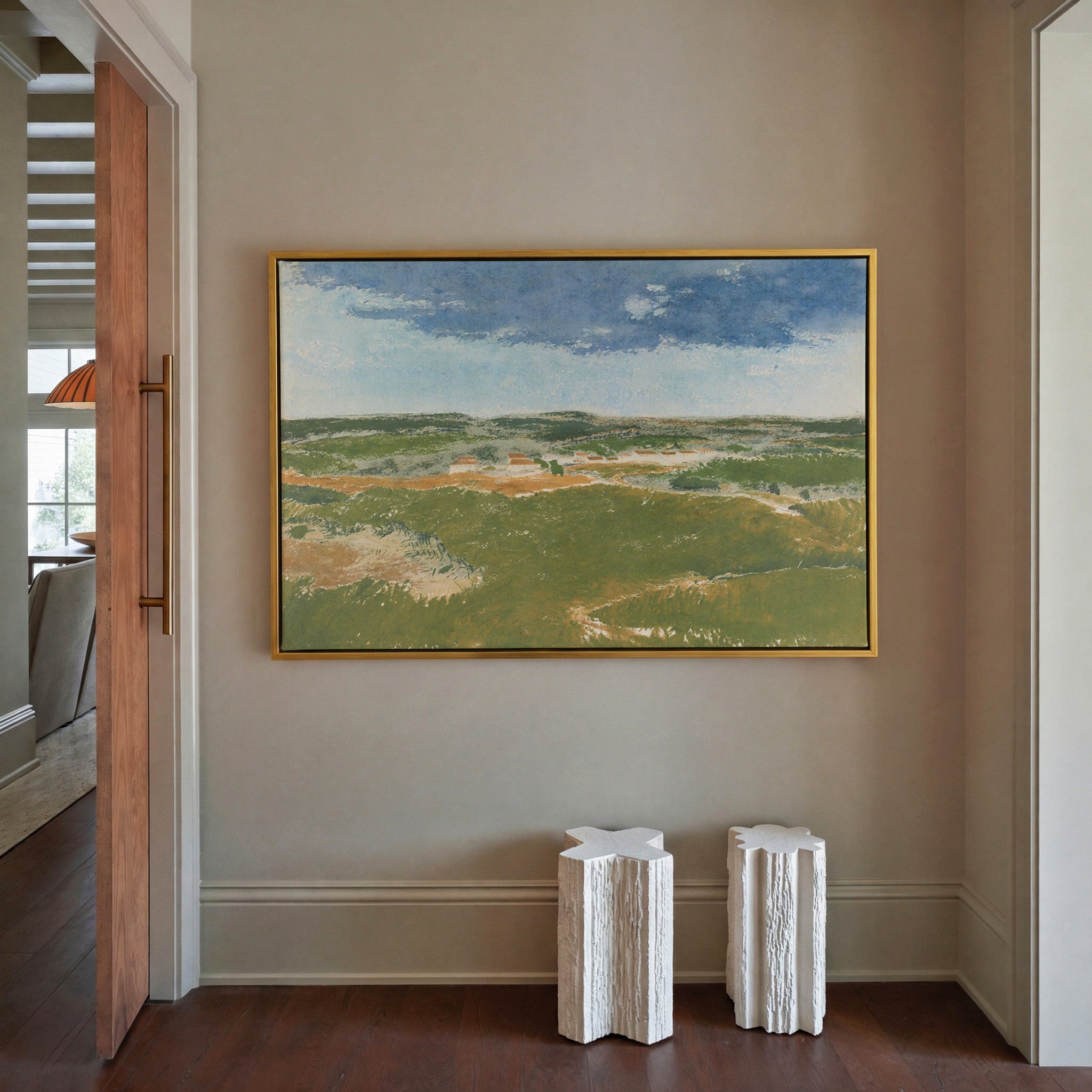 green dunes under a broad blue sky canvas wall art in a gold frame in a styled room setting