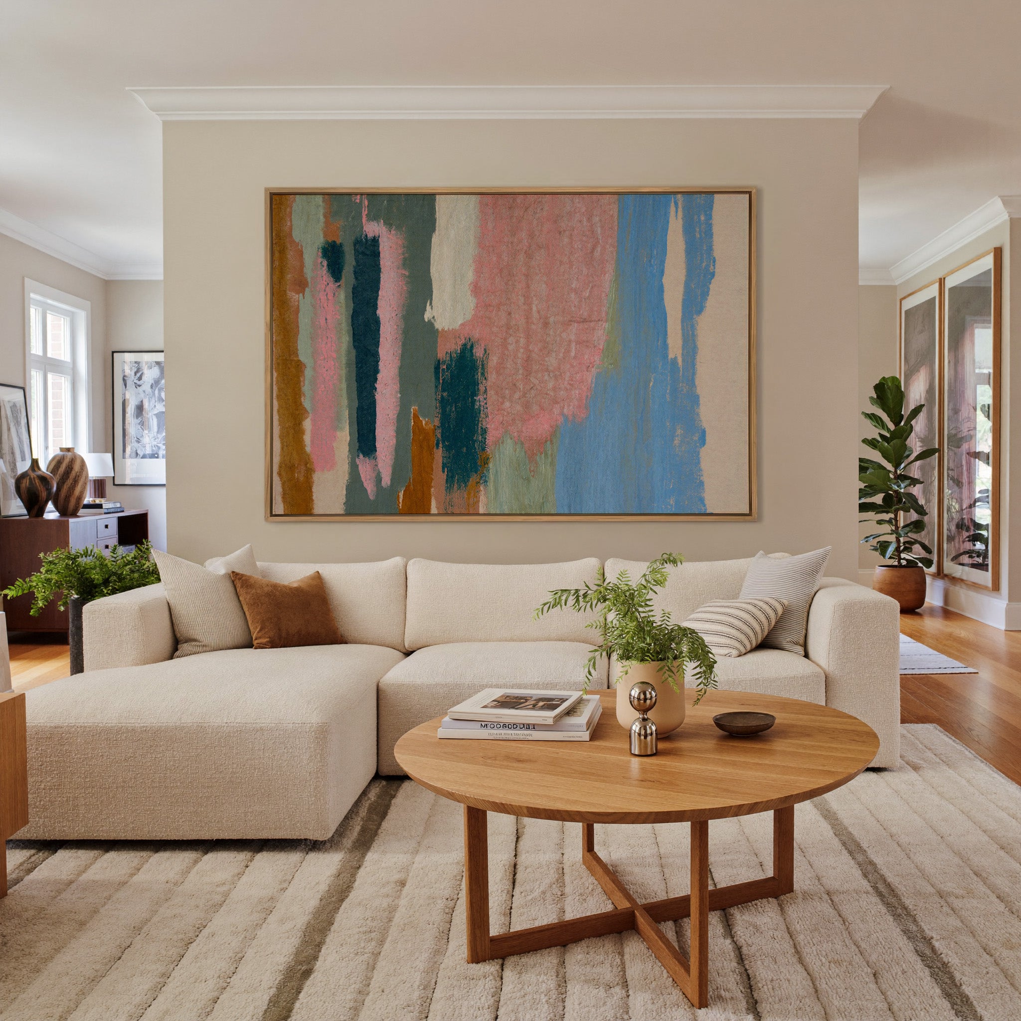 vertical abstract with pink, blue, teal, and canvas wall art in an oak frame in a living room