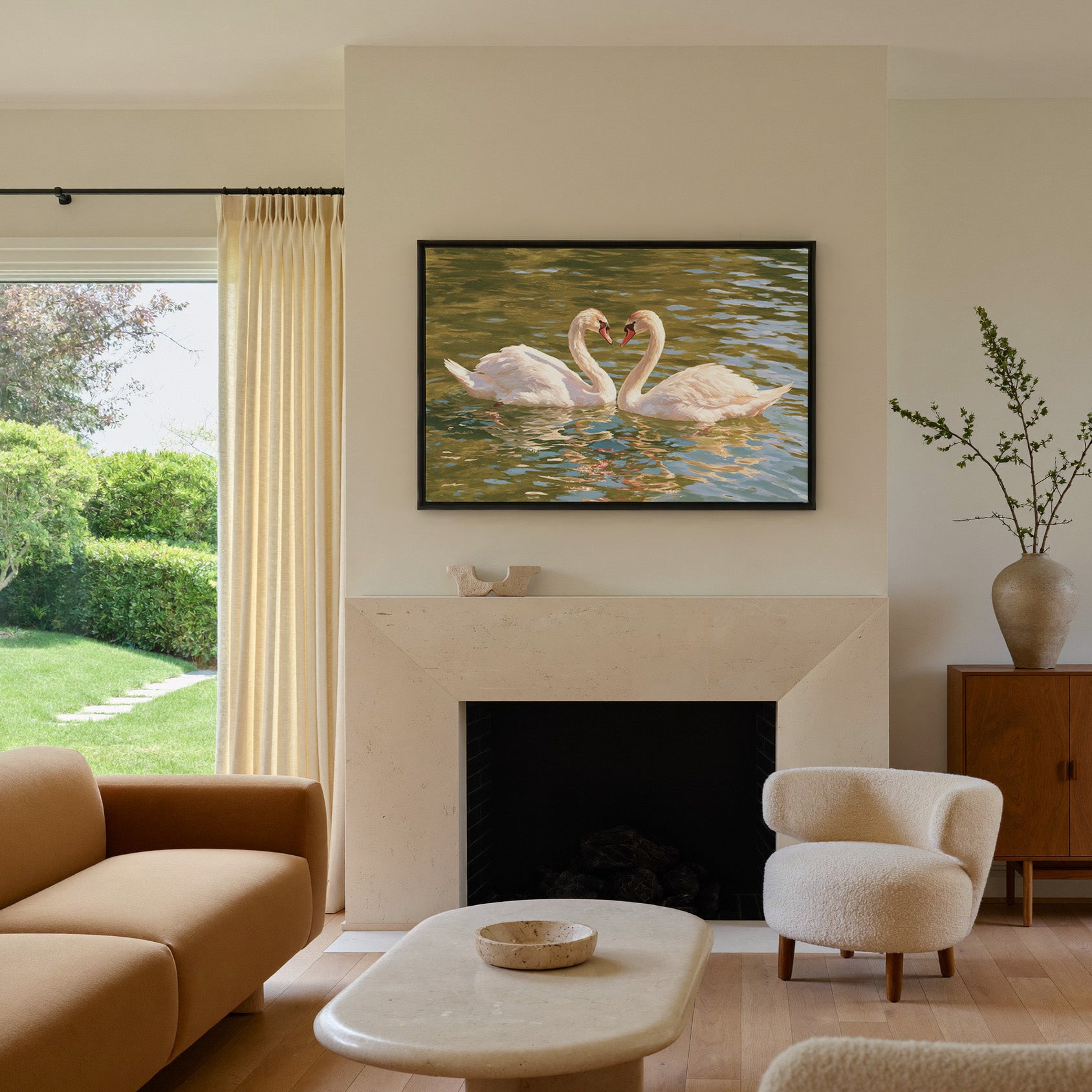 two white swans facing each other on green water canvas wall art in a black frame above a mantel