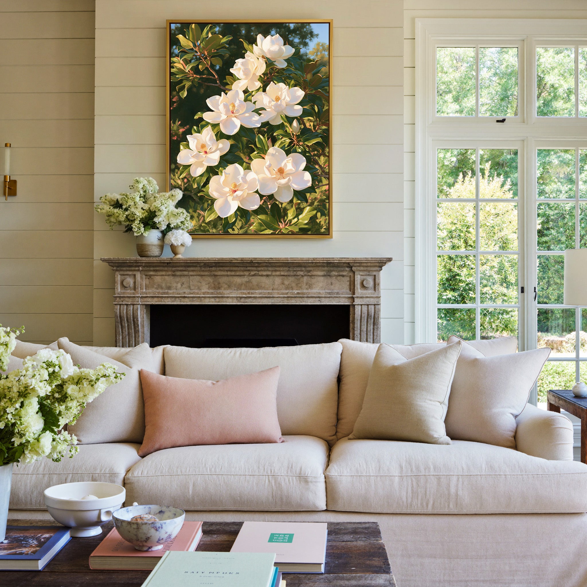 white magnolia blossoms with glossy green canvas wall art in a gold frame above a mantel