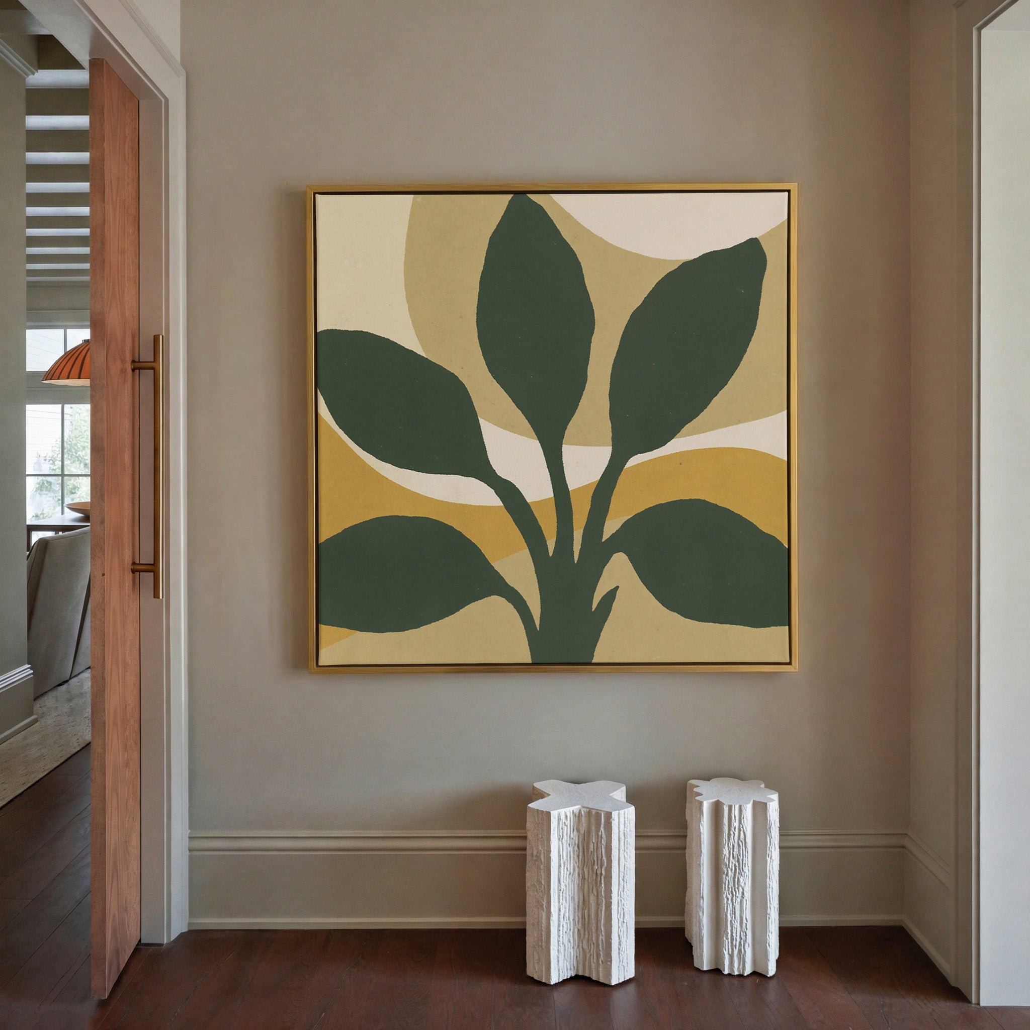 dark green leaf forms with warm ochre arcs canvas wall art in a gold frame in a styled room setting