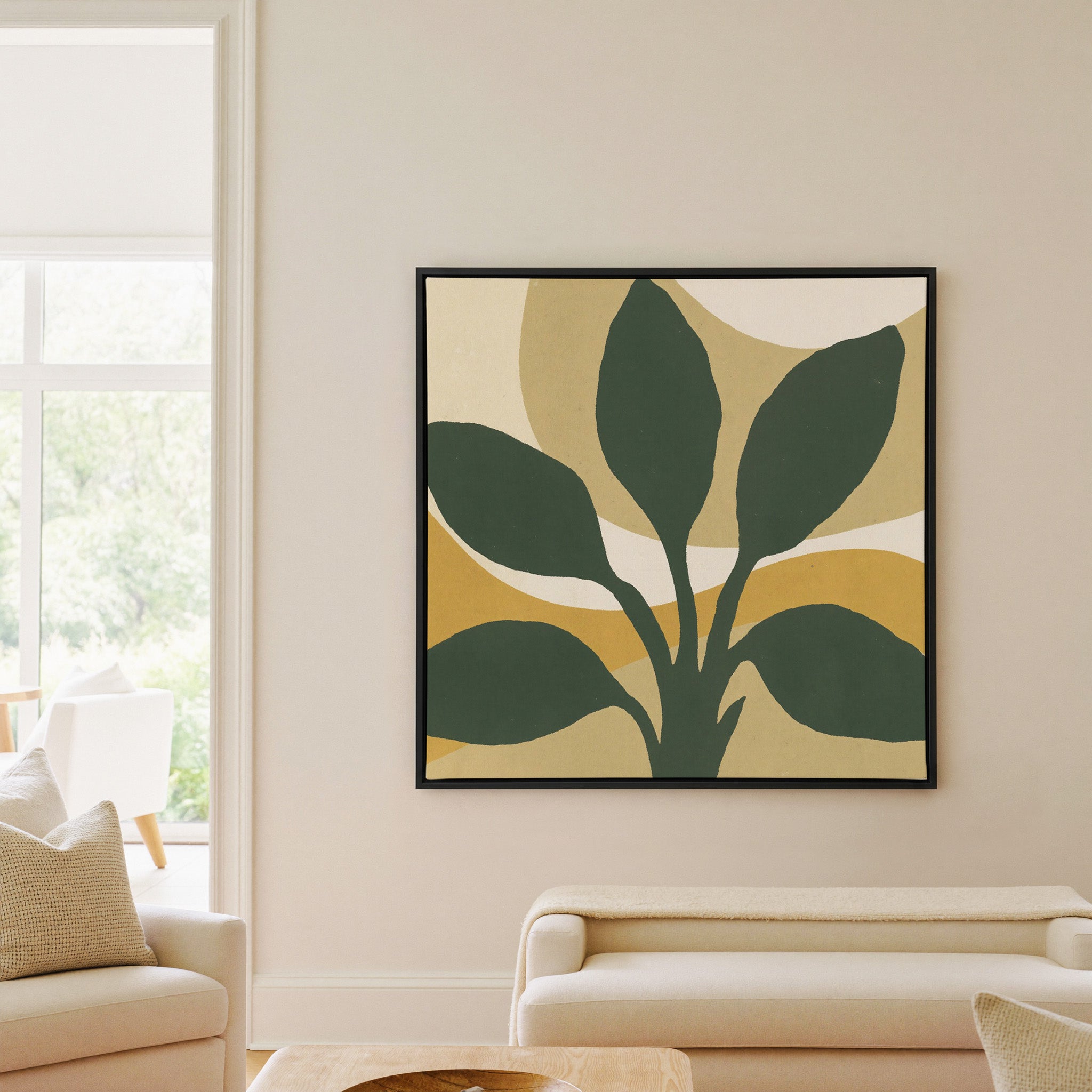 dark green leaf forms with warm ochre arcs canvas wall art in a black frame in a living room