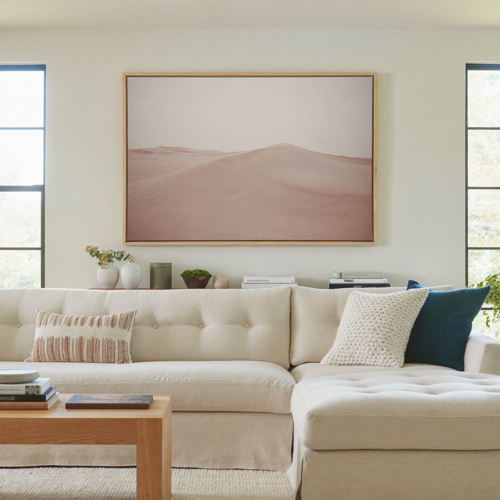 soft blush desert dunes canvas wall art in a natural wood frame in a living room