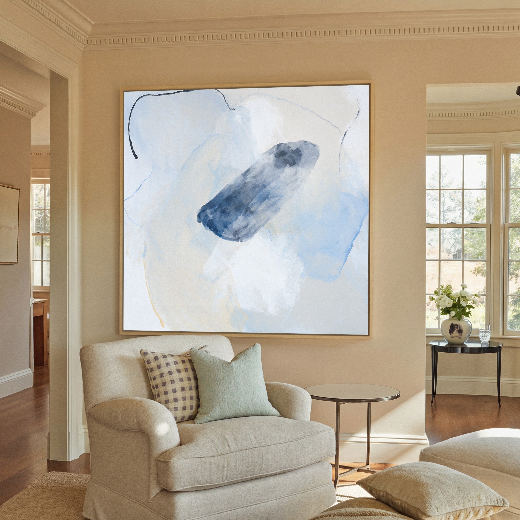 soft blue and ivory abstract with canvas wall art in a natural wood frame in a styled room setting