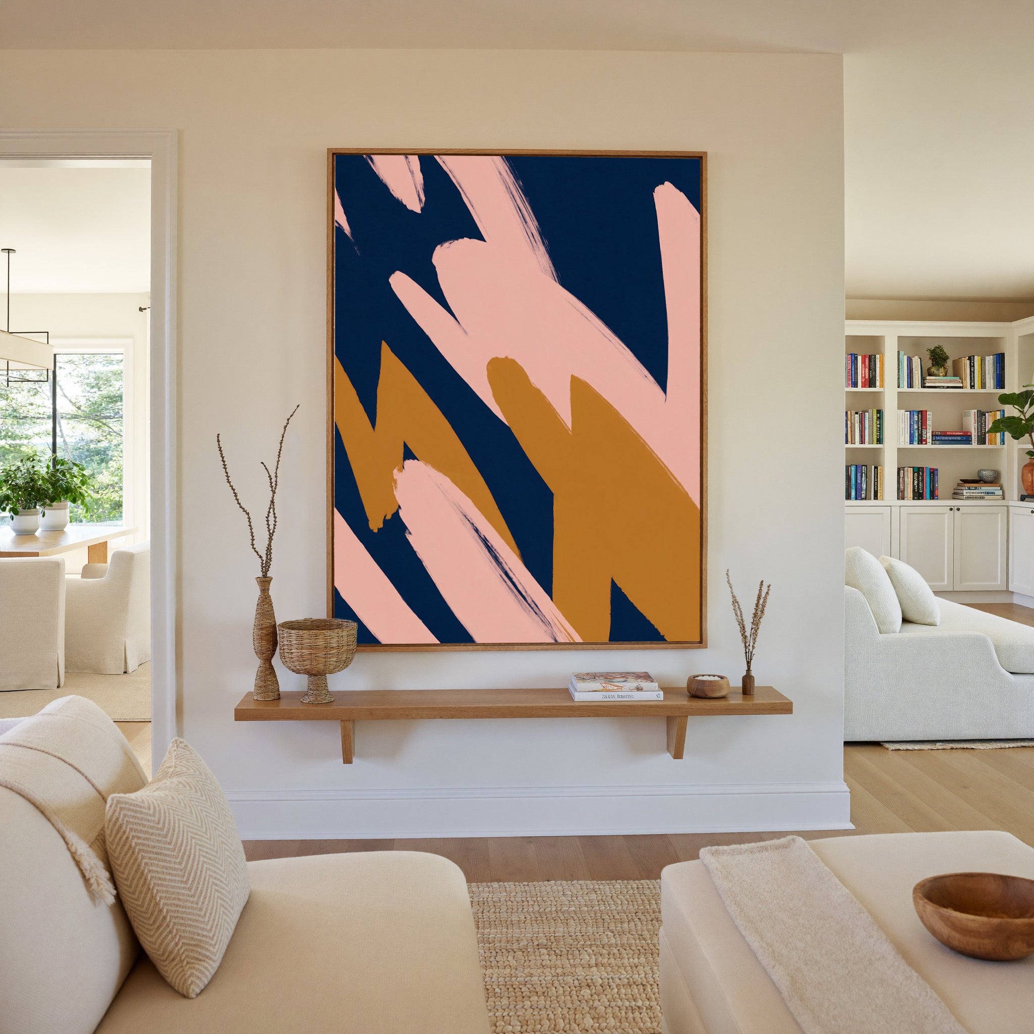 navy abstract with blush and ochre brush shapes canvas wall art in an oak frame in a living room