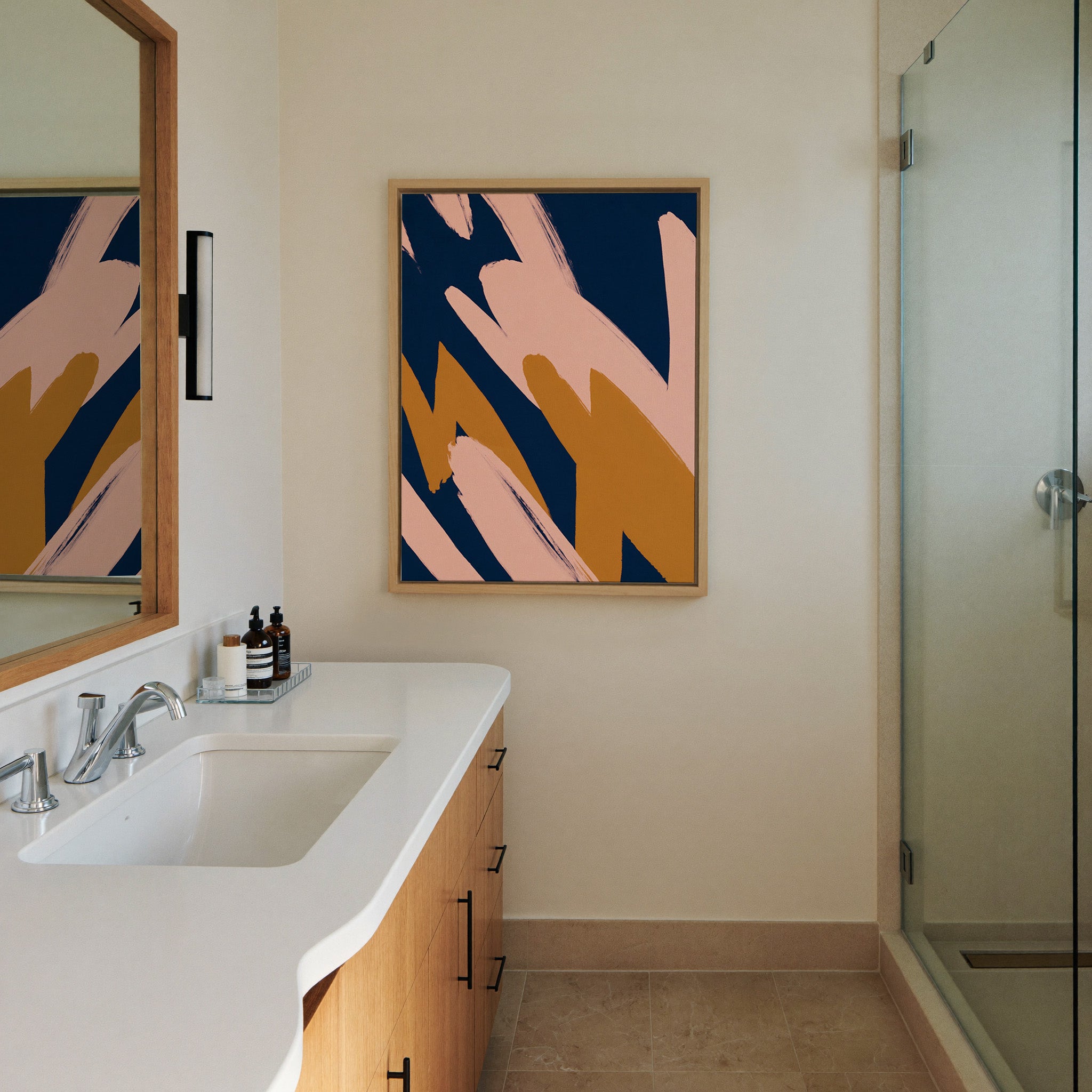 navy abstract with blush and canvas wall art in a natural wood frame in a styled room setting
