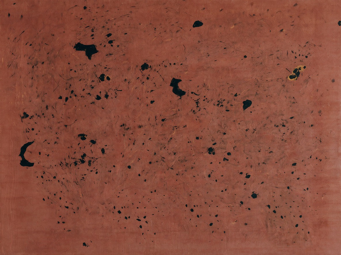Rust red abstract field with scattered black marks and a small gold accent across the upper right