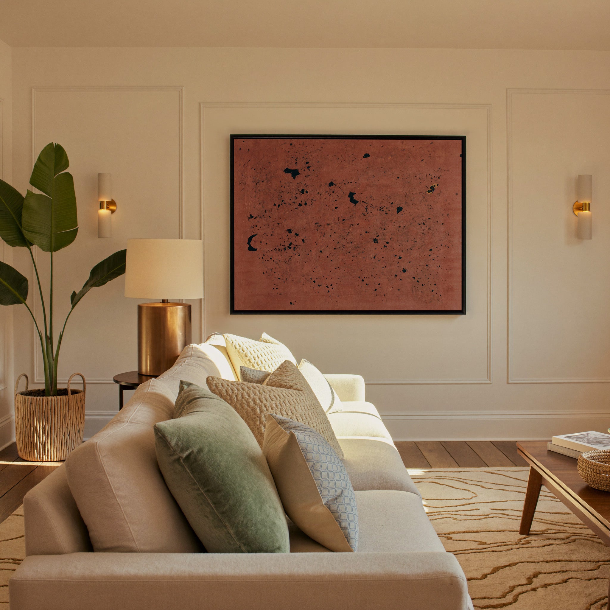 rust red abstract with scattered black marks canvas wall art in a black frame in a styled room setting