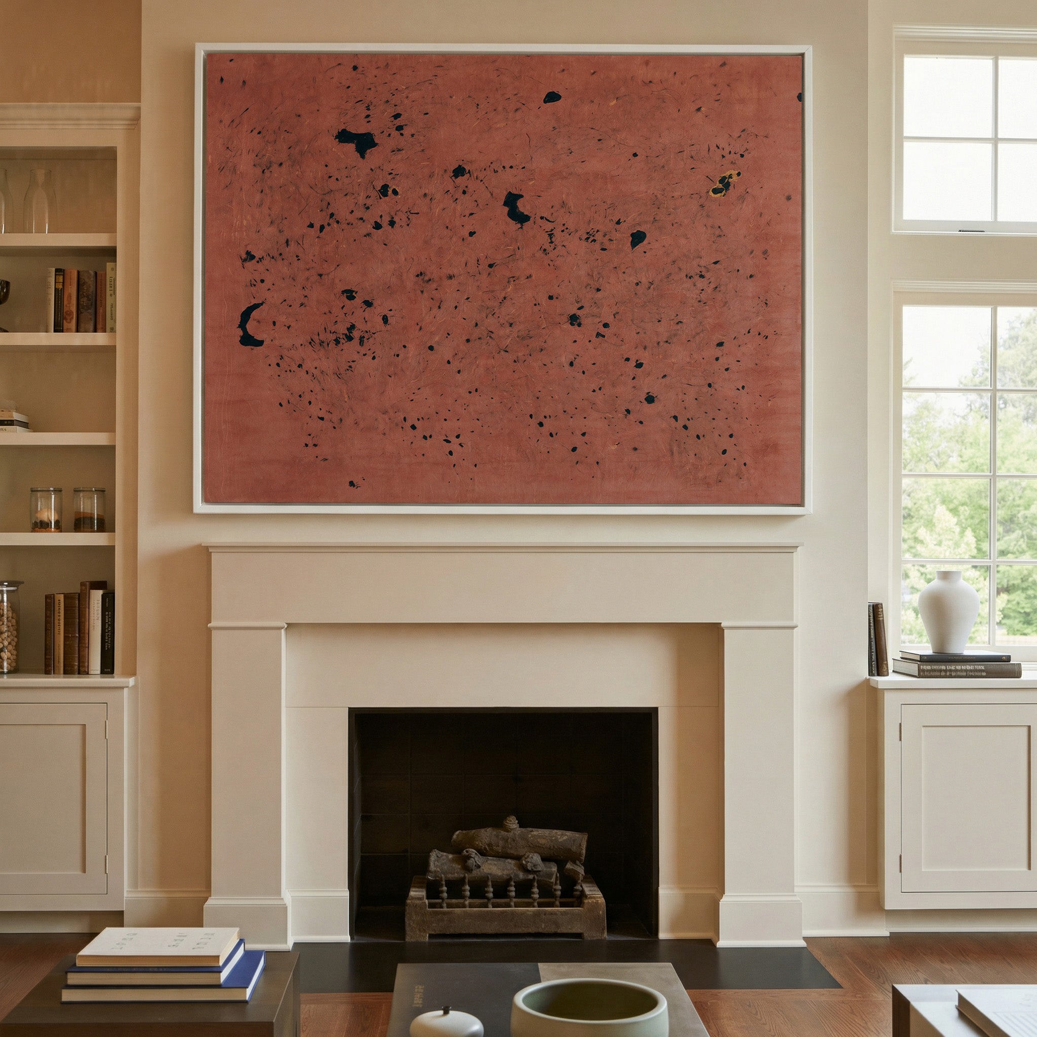 rust red abstract with scattered black marks canvas wall art in a white frame above a mantel
