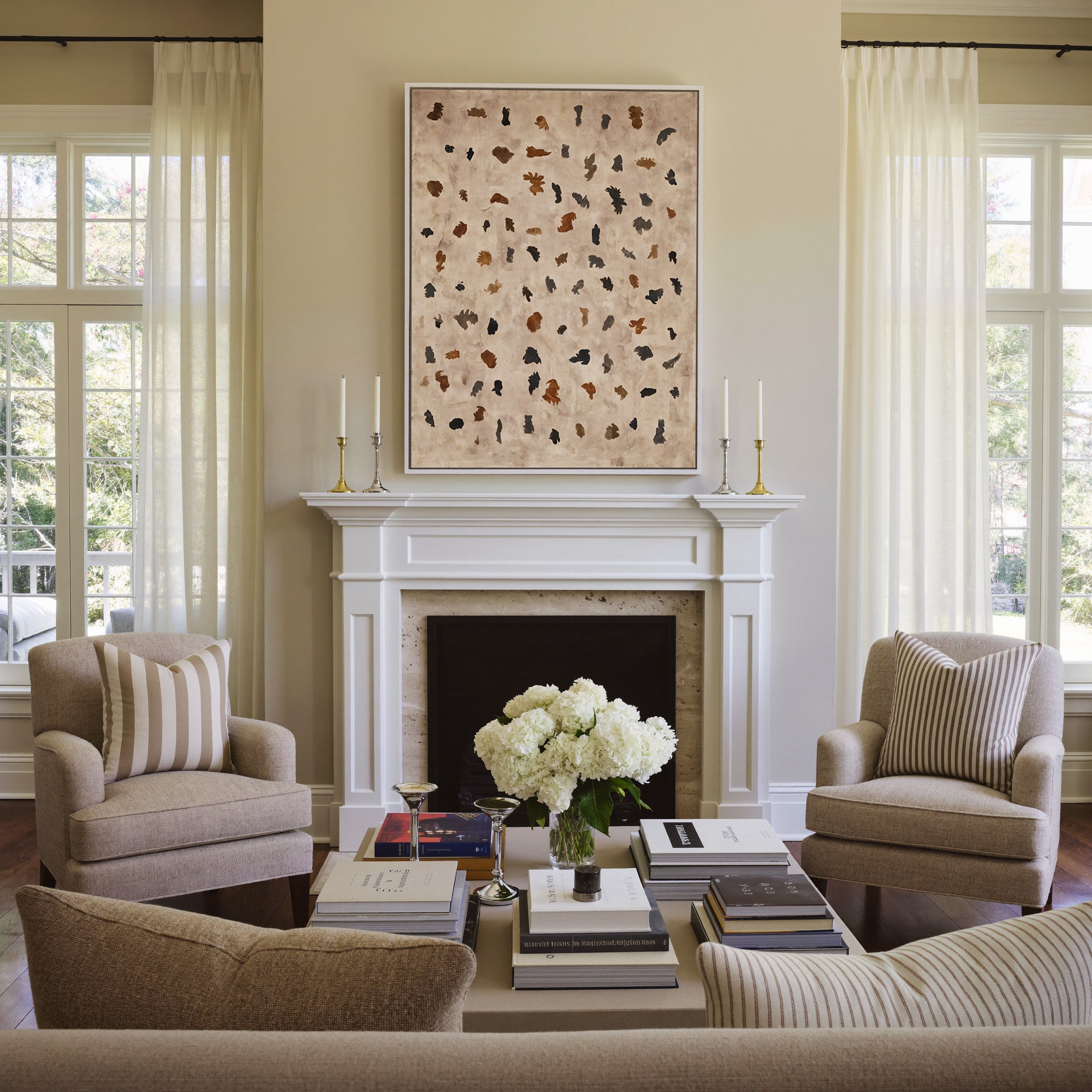 beige abstract with scattered black and rust canvas wall art in a white frame above a mantel