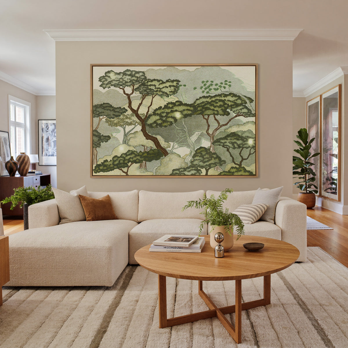 layered trees with pale green clouds and canvas wall art in an oak frame in a living room