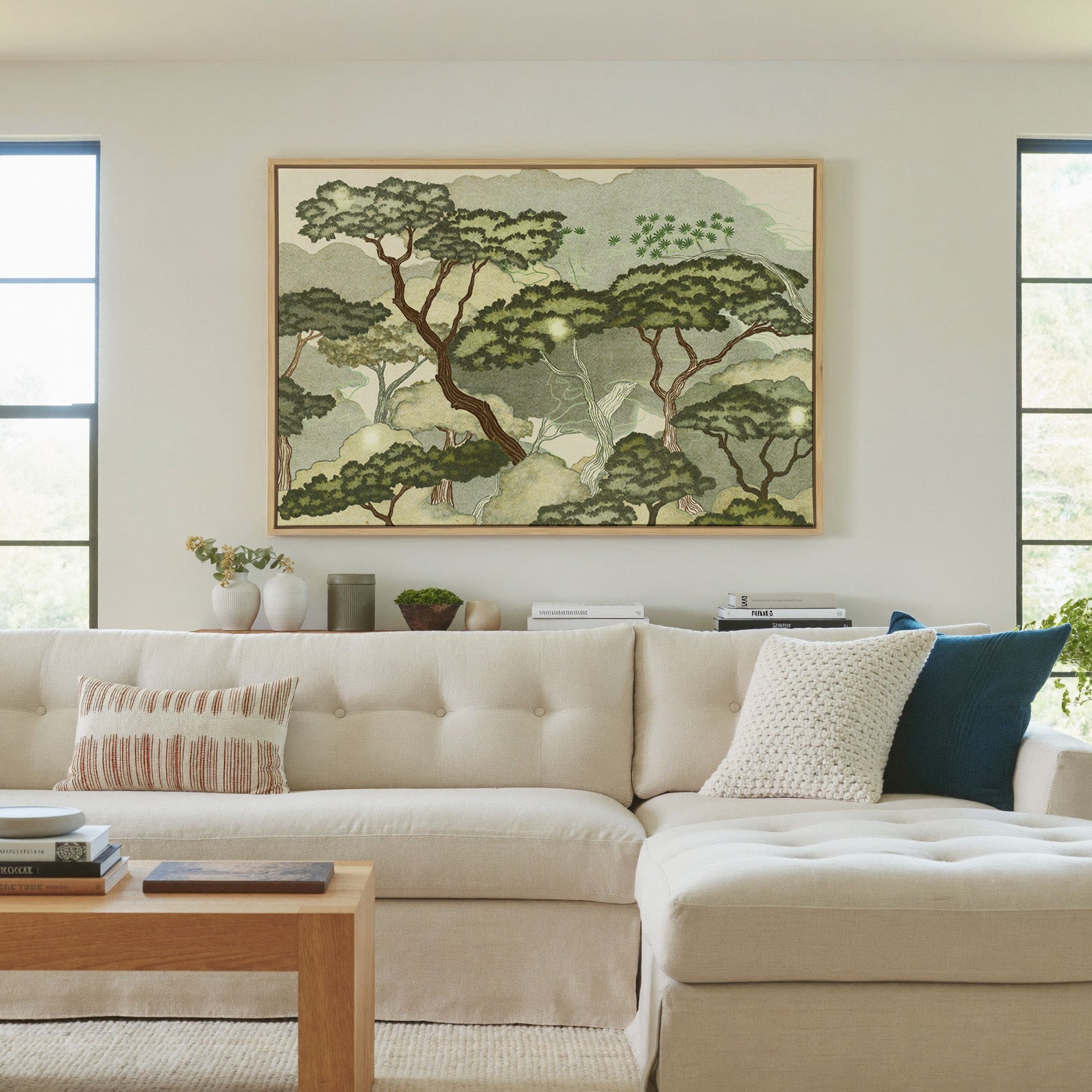 layered trees with pale green clouds and canvas wall art in a natural wood frame in a living room