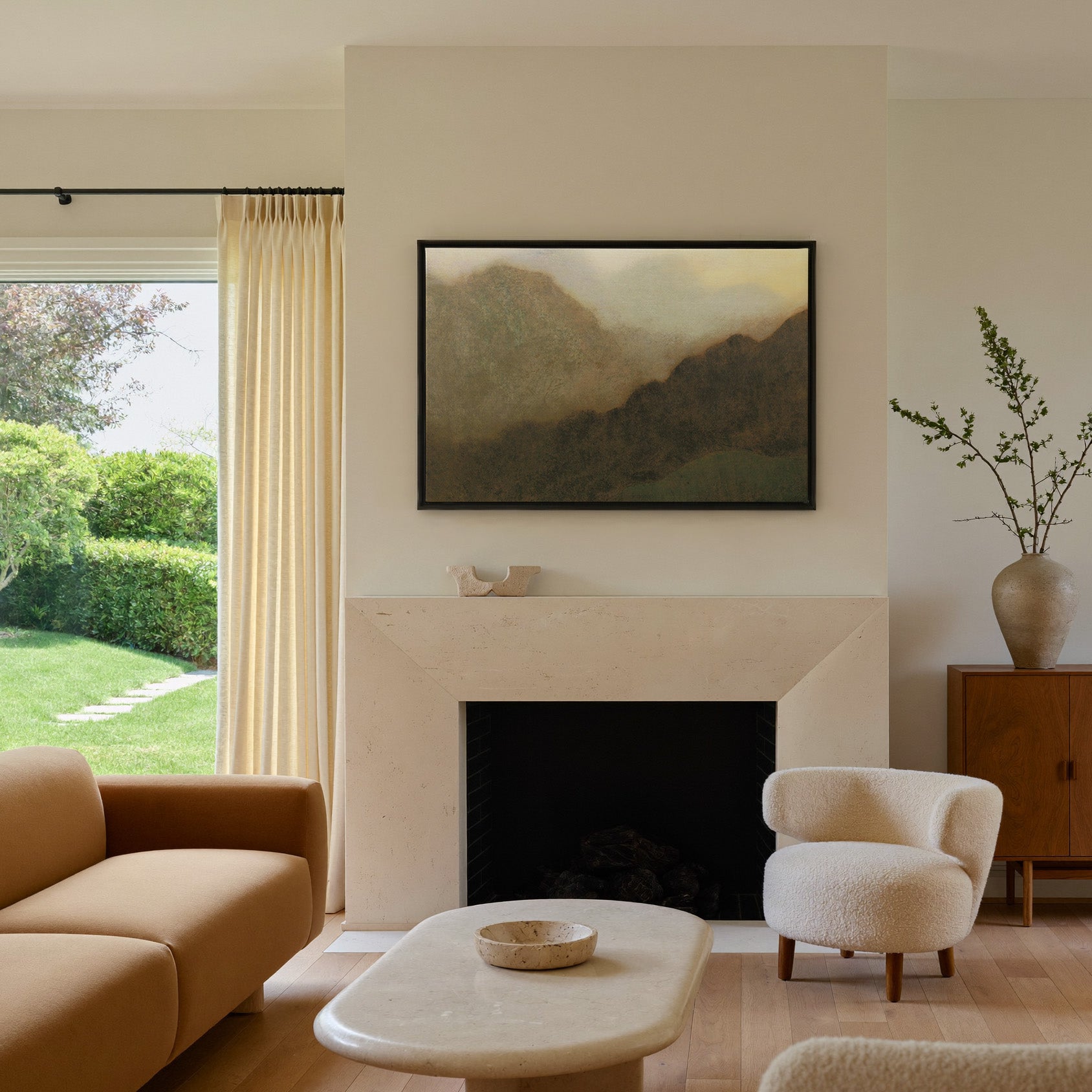 misty brown mountain landscape canvas wall art in a black frame above a mantel