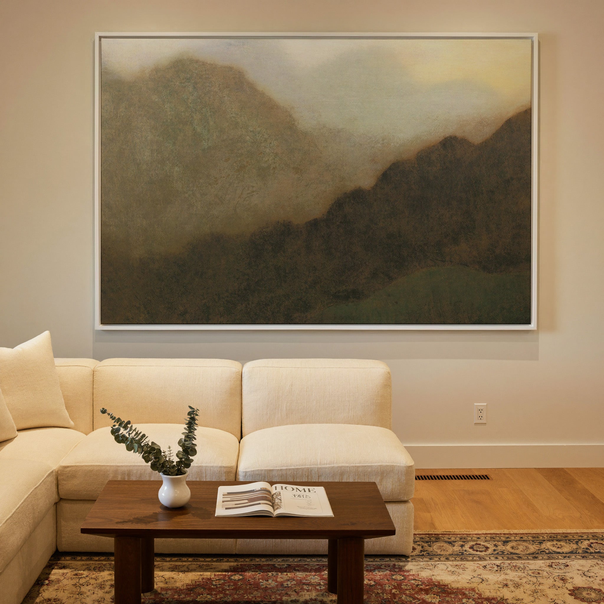 misty brown mountain landscape canvas wall art in a white frame in a styled room setting