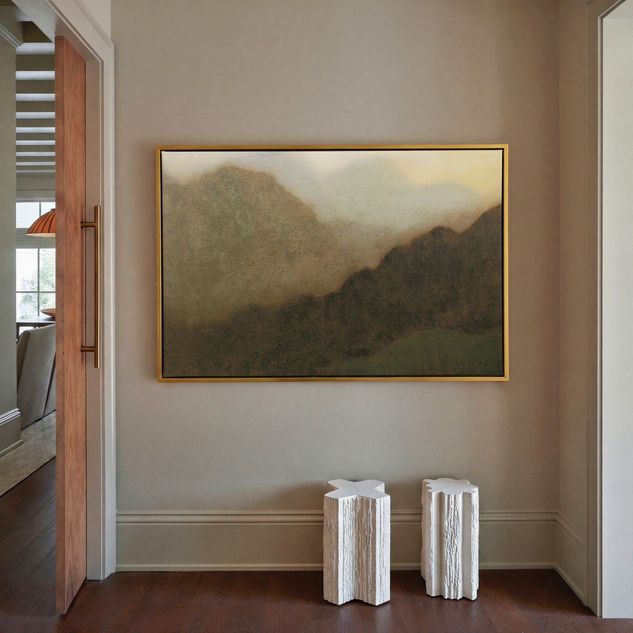 misty brown mountain landscape canvas wall art in a gold frame in a styled room setting