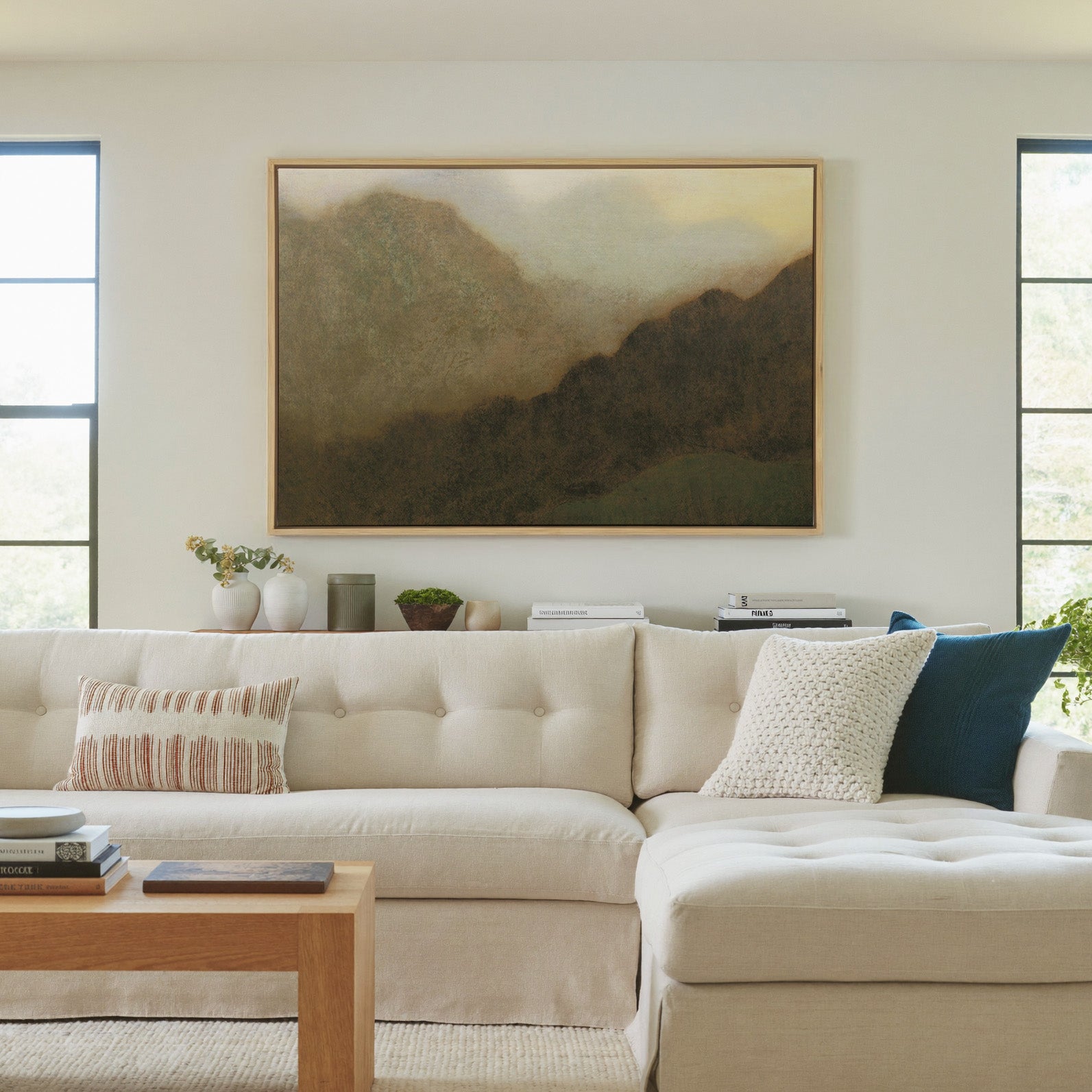 misty brown mountain landscape canvas wall art in a natural wood frame in a living room