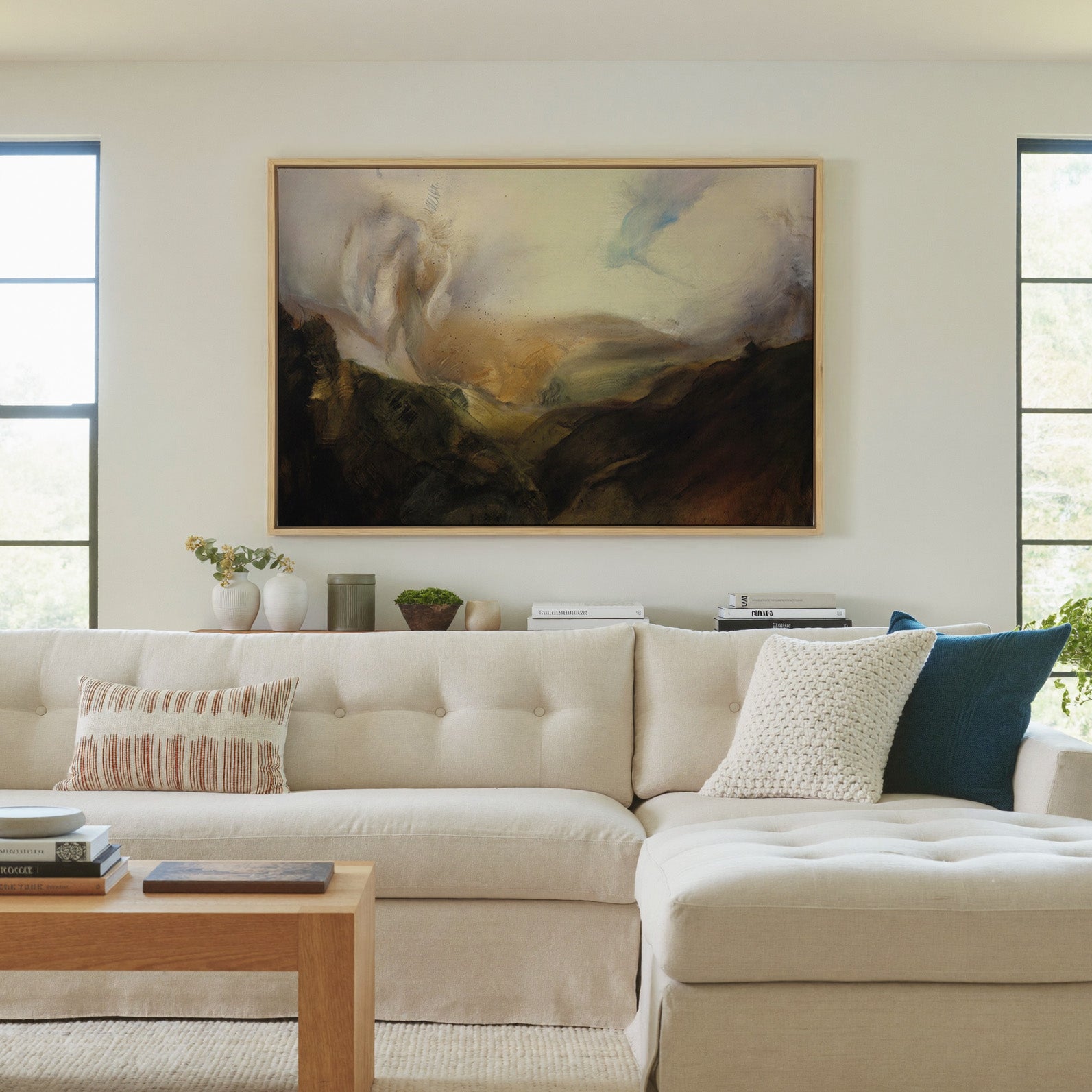 misty mountain landscape with dark foreground canvas wall art in a natural wood frame in a living room