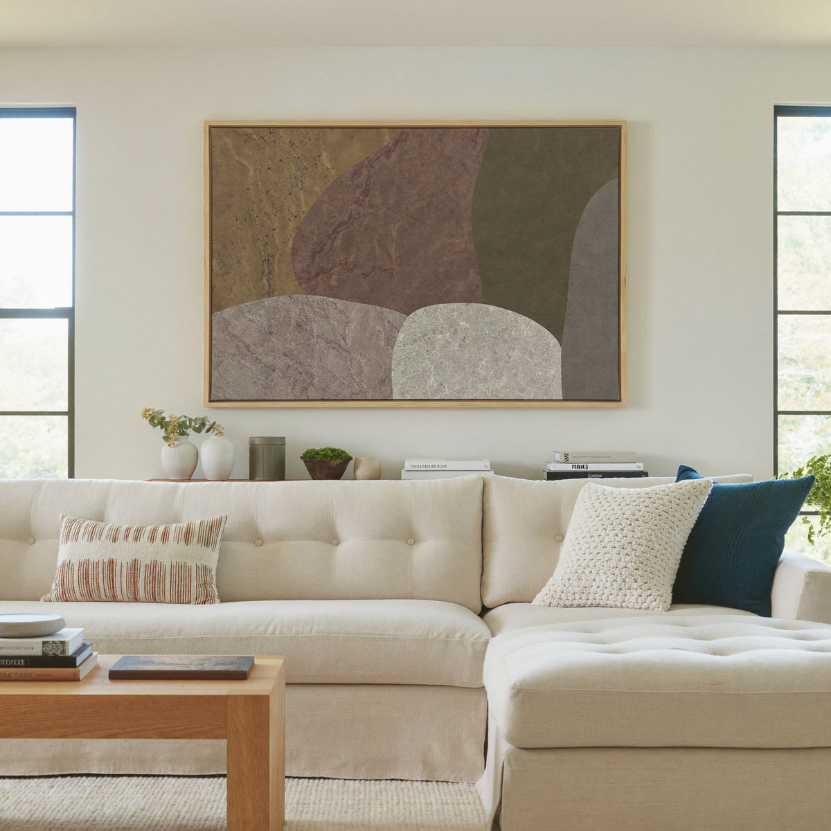 earthy abstract with arched stone like forms canvas wall art in a natural wood frame in a living room