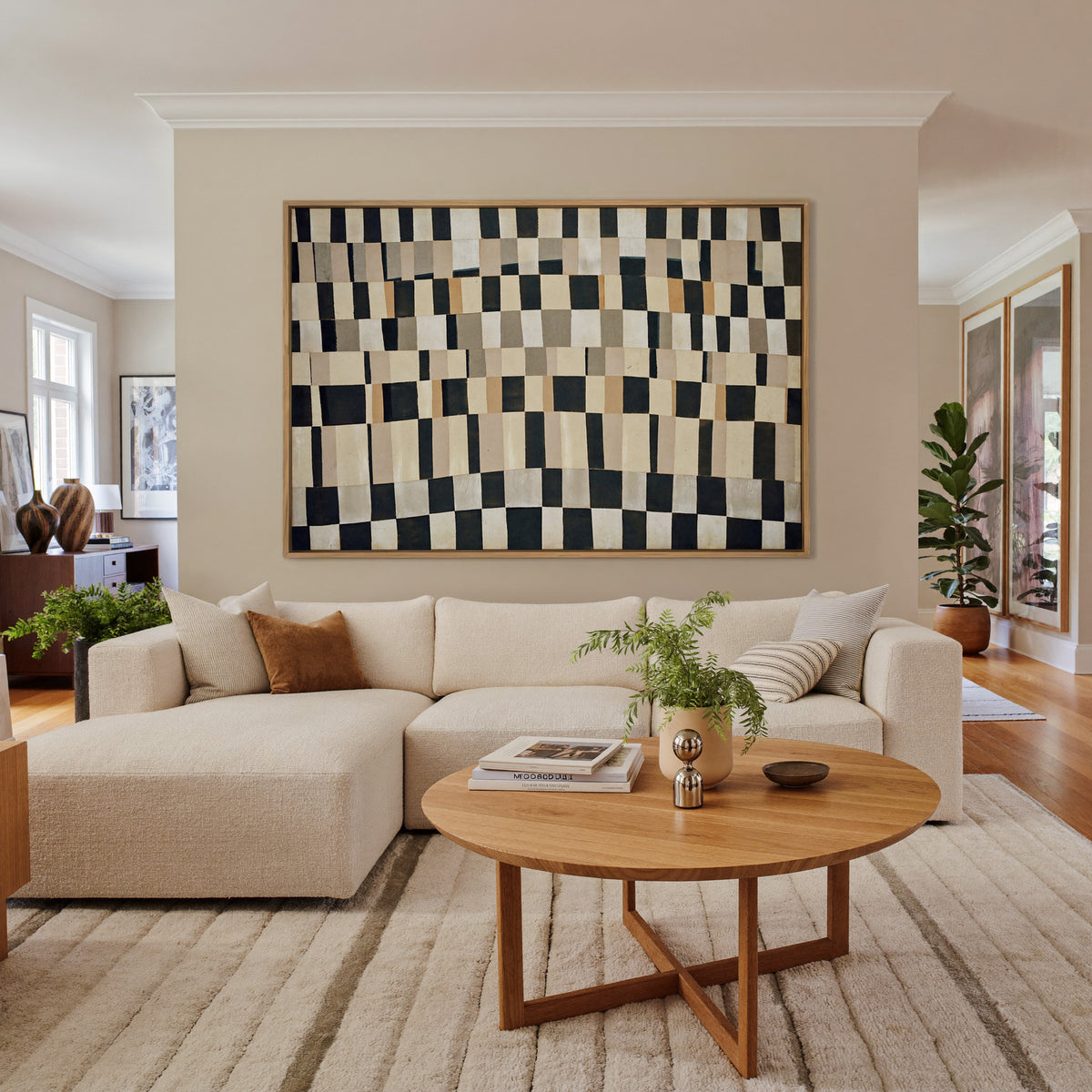 curved black, cream, and tan checker abstract canvas wall art in an oak frame in a living room
