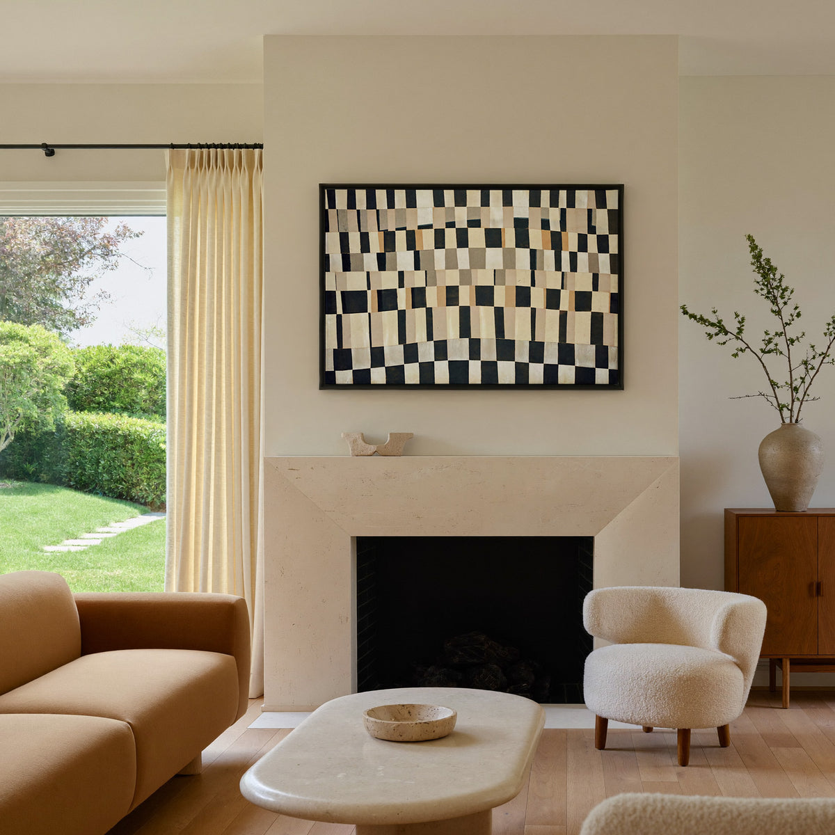 curved black, cream, and tan checker abstract canvas wall art in a black frame above a mantel