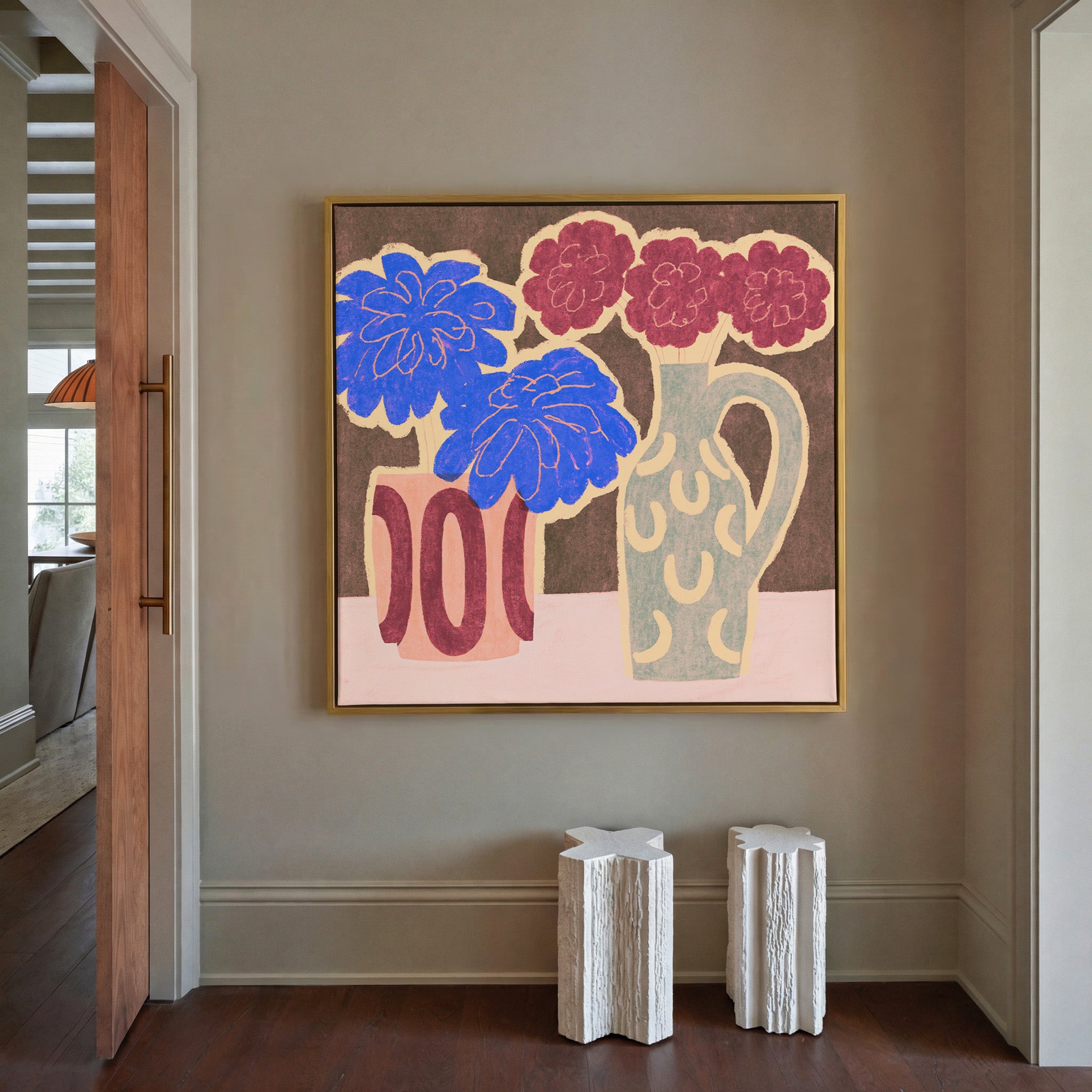 bold blue and burgundy flowers in patterned canvas wall art in a gold frame in a styled room setting