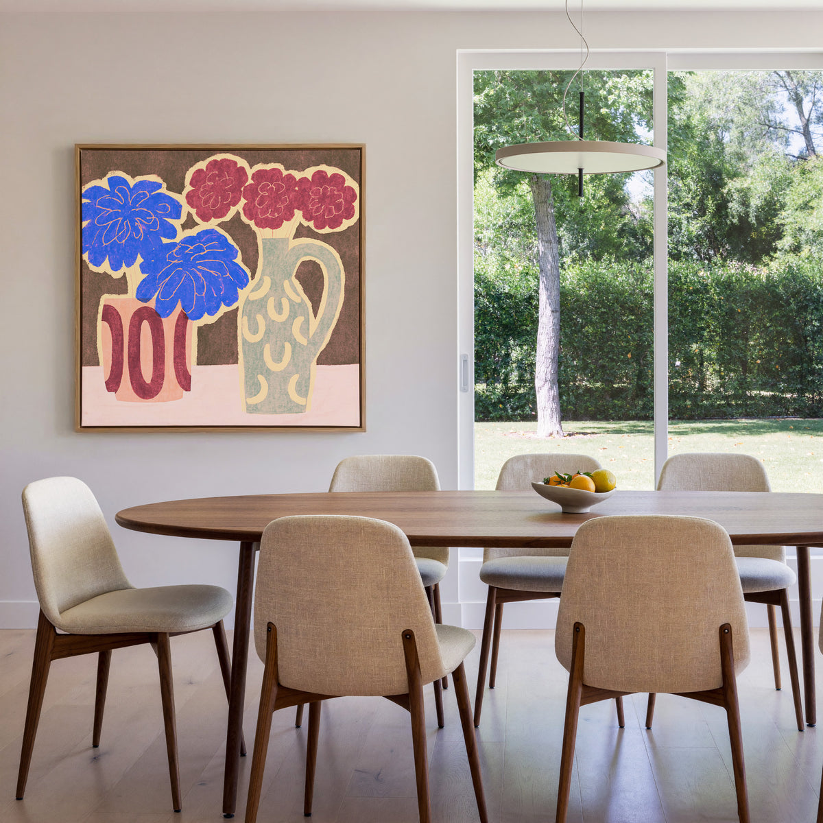 bold blue and burgundy flowers in patterned canvas wall art in an oak frame in a dining room