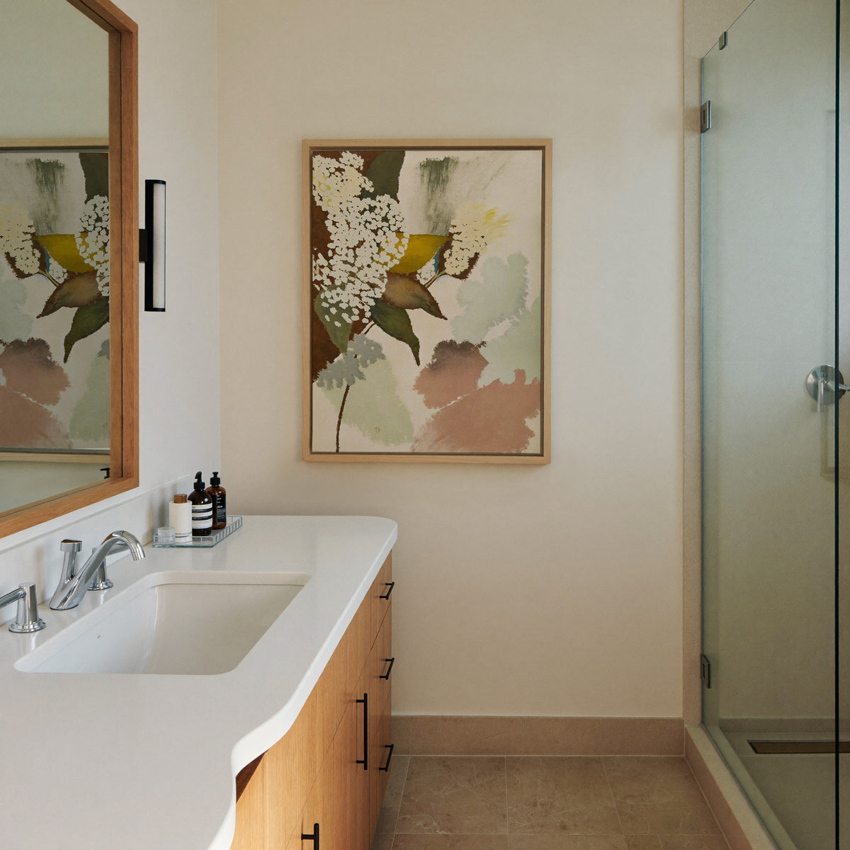 soft botanical abstract with pale canvas wall art in a natural wood frame in a styled room setting