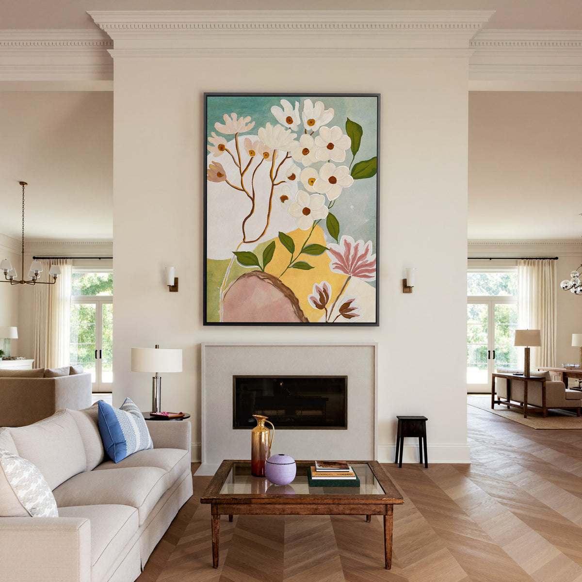 soft white blossoms with green leaves on a pale canvas wall art in a black frame above a mantel