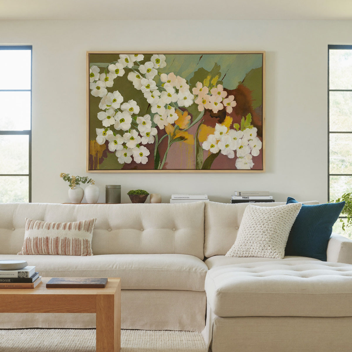 white and blush floral abstract with olive canvas wall art in a natural wood frame in a living room