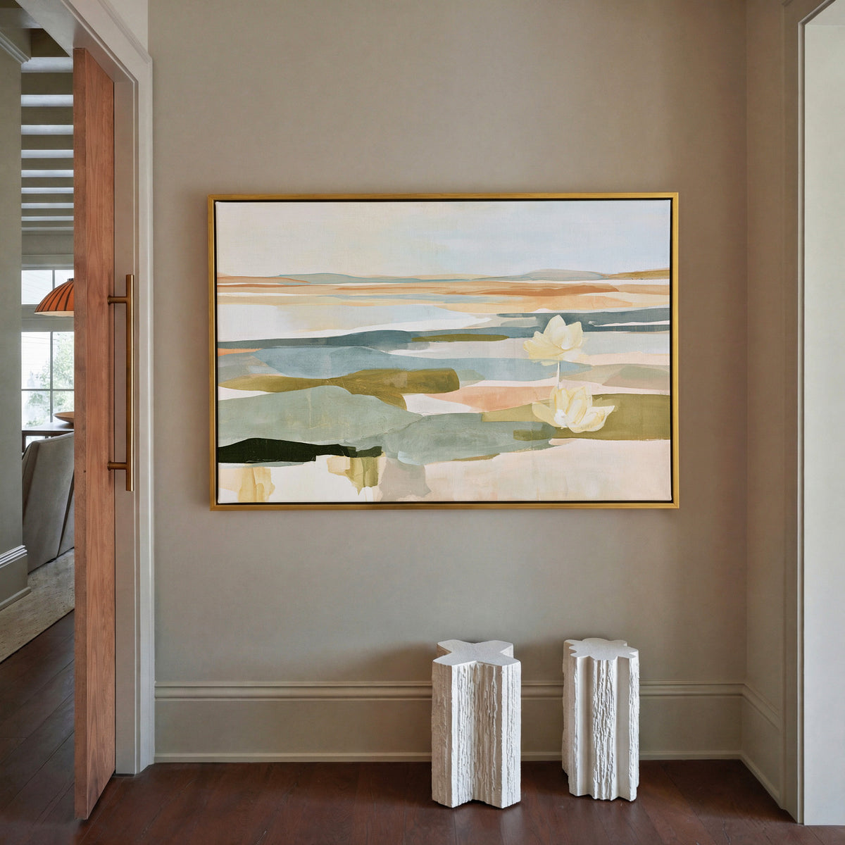 soft blue green and ochre abstract with white canvas wall art in a gold frame in a styled room setting