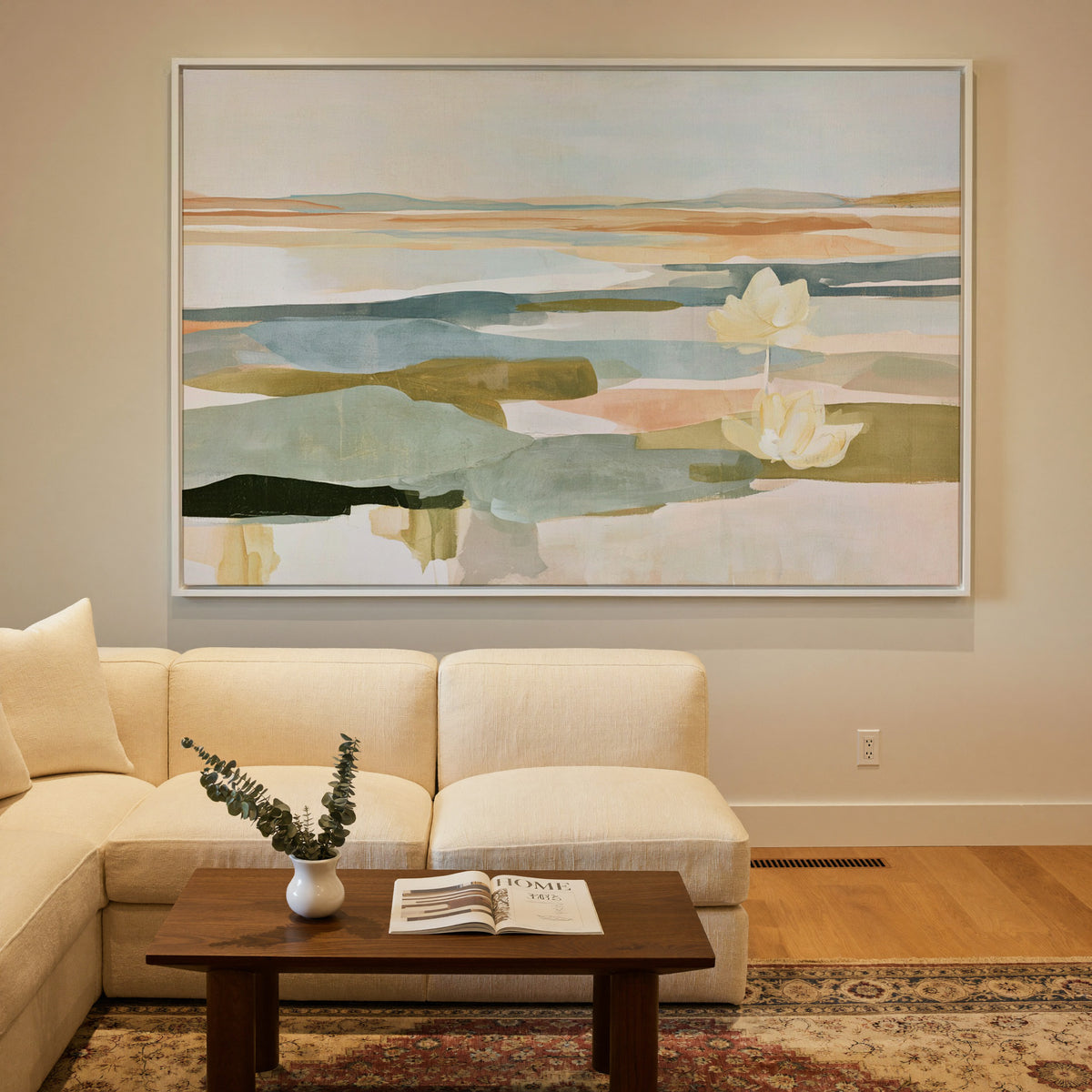 soft blue green and ochre abstract with white canvas wall art in a white frame in a styled room setting