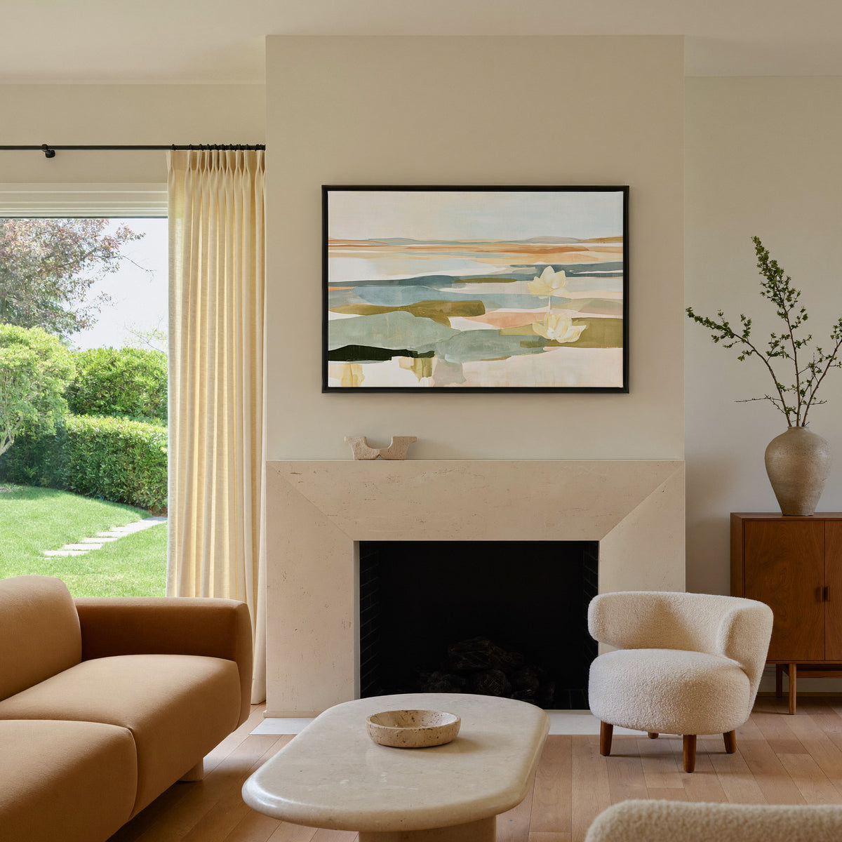 soft blue green and ochre abstract with white canvas wall art in a black frame above a mantel