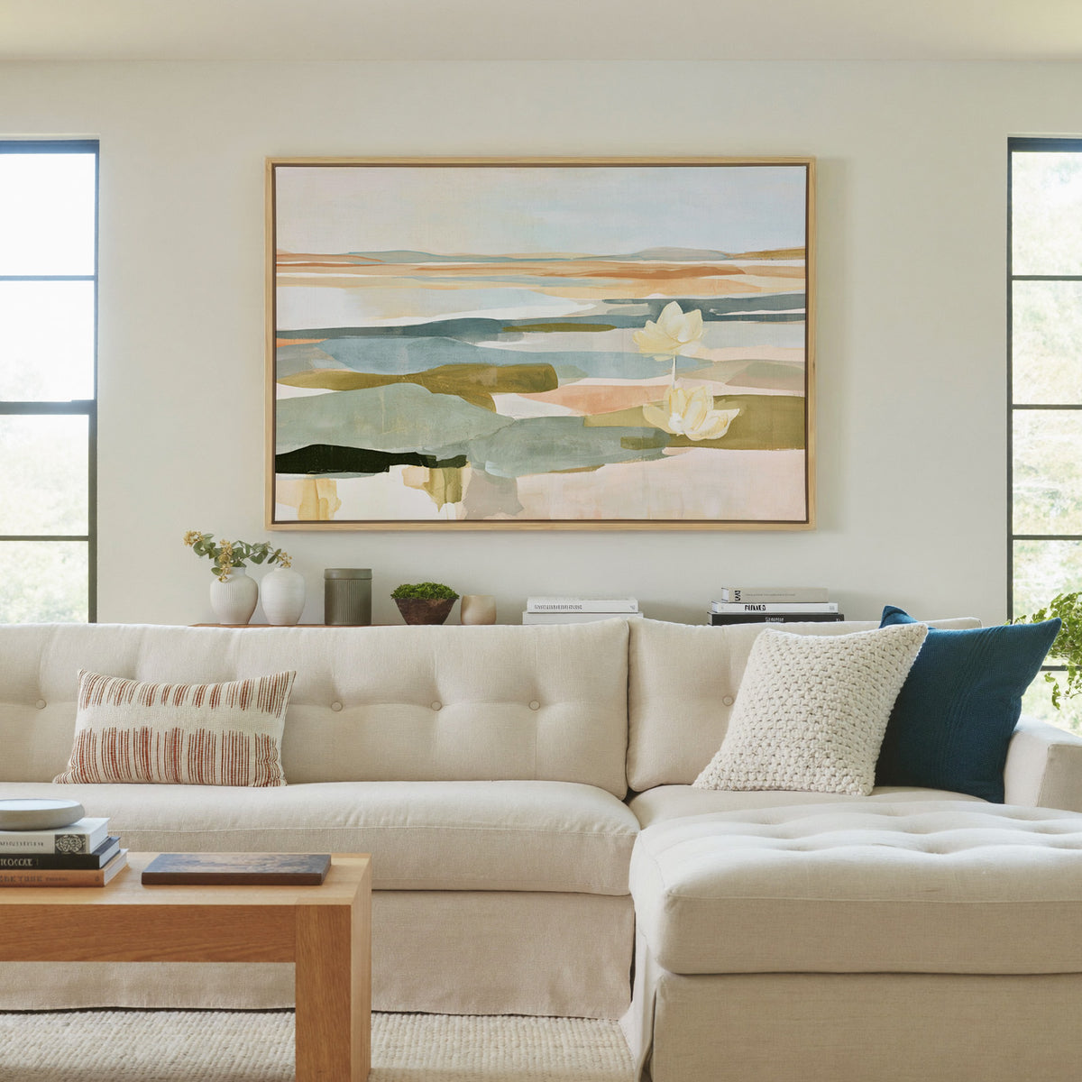 soft blue green and ochre abstract with white canvas wall art in a natural wood frame in a living room