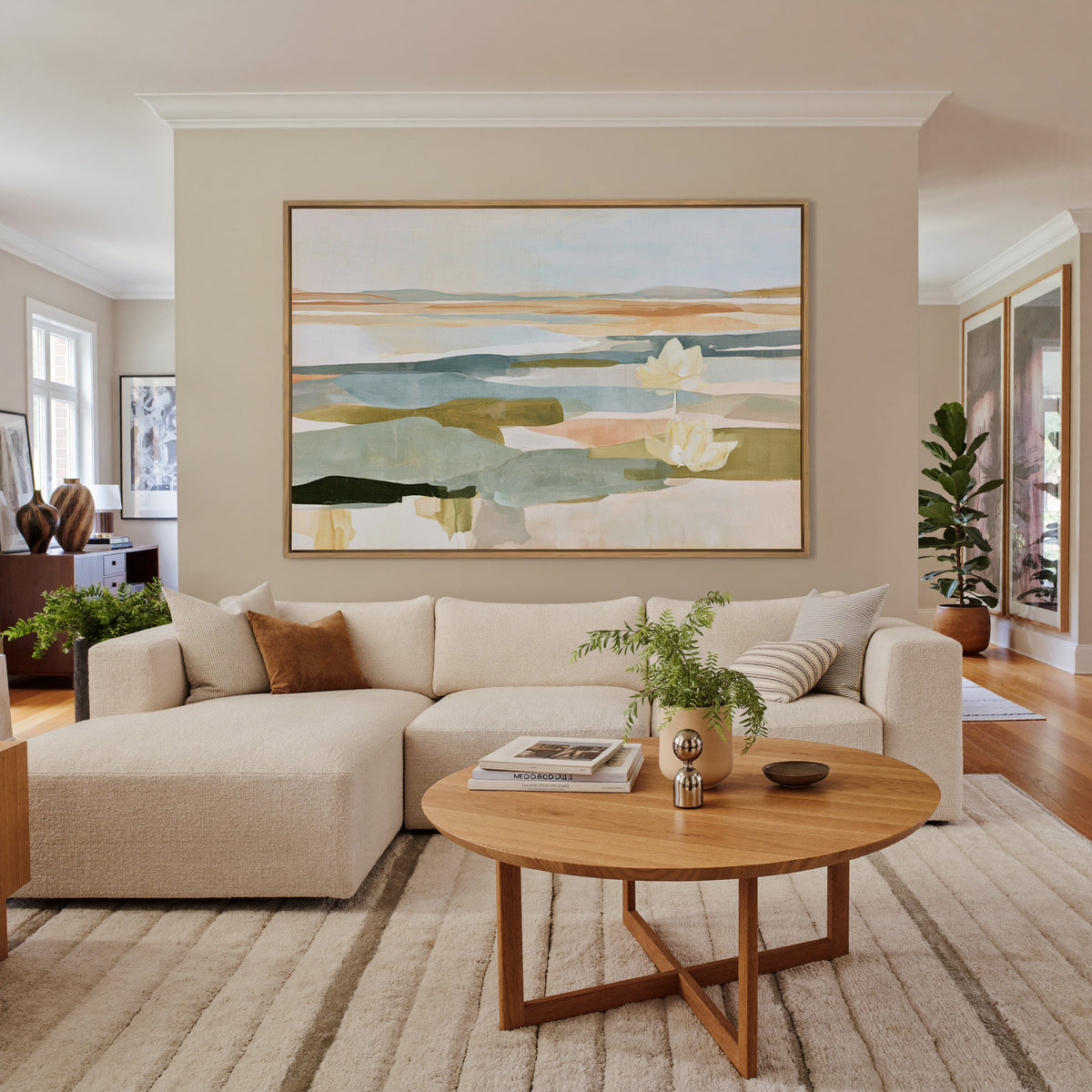soft blue green and ochre abstract with white canvas wall art in an oak frame in a living room