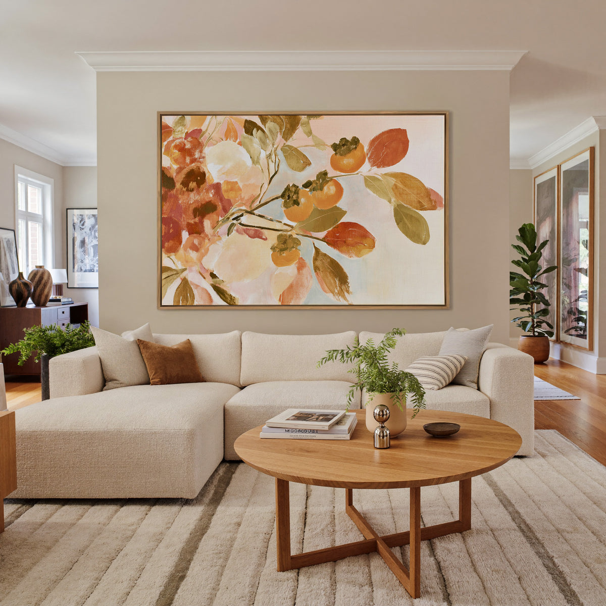 late autumn persimmon branches with orange canvas wall art in an oak frame in a living room