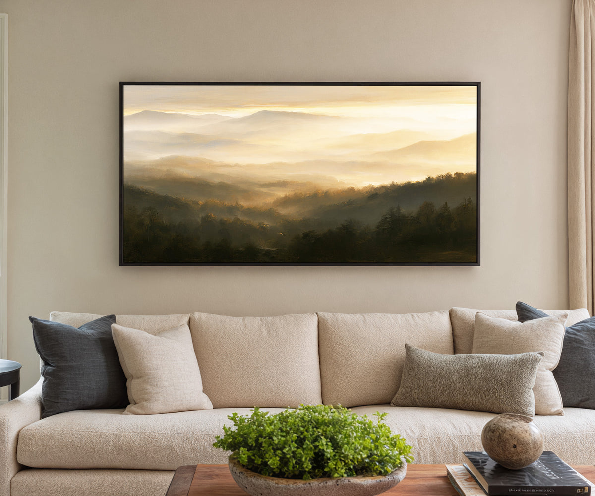 layered misty mountain landscape at sunrise canvas wall art in a black frame in a styled room setting