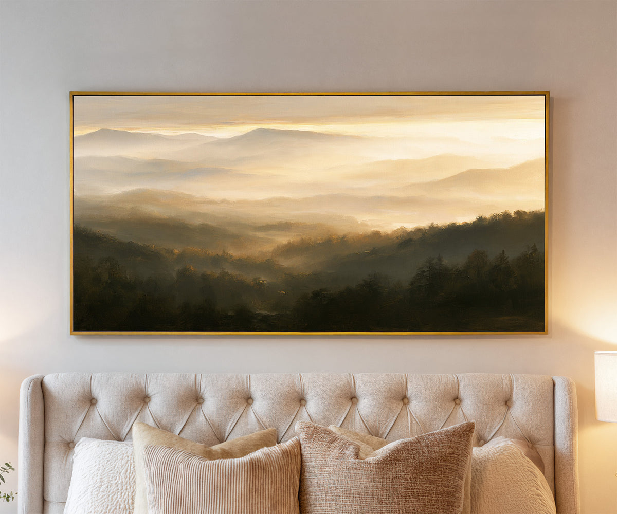 layered misty mountain landscape at sunrise canvas wall art in a gold frame above a bed