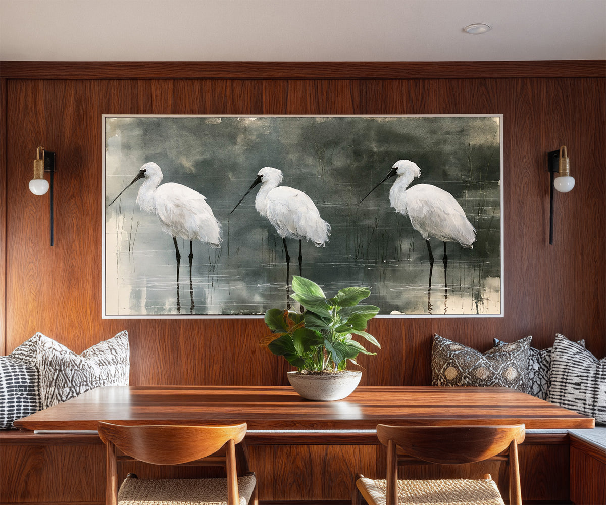 three white birds in shallow marsh water canvas wall art in a white frame in a styled room setting