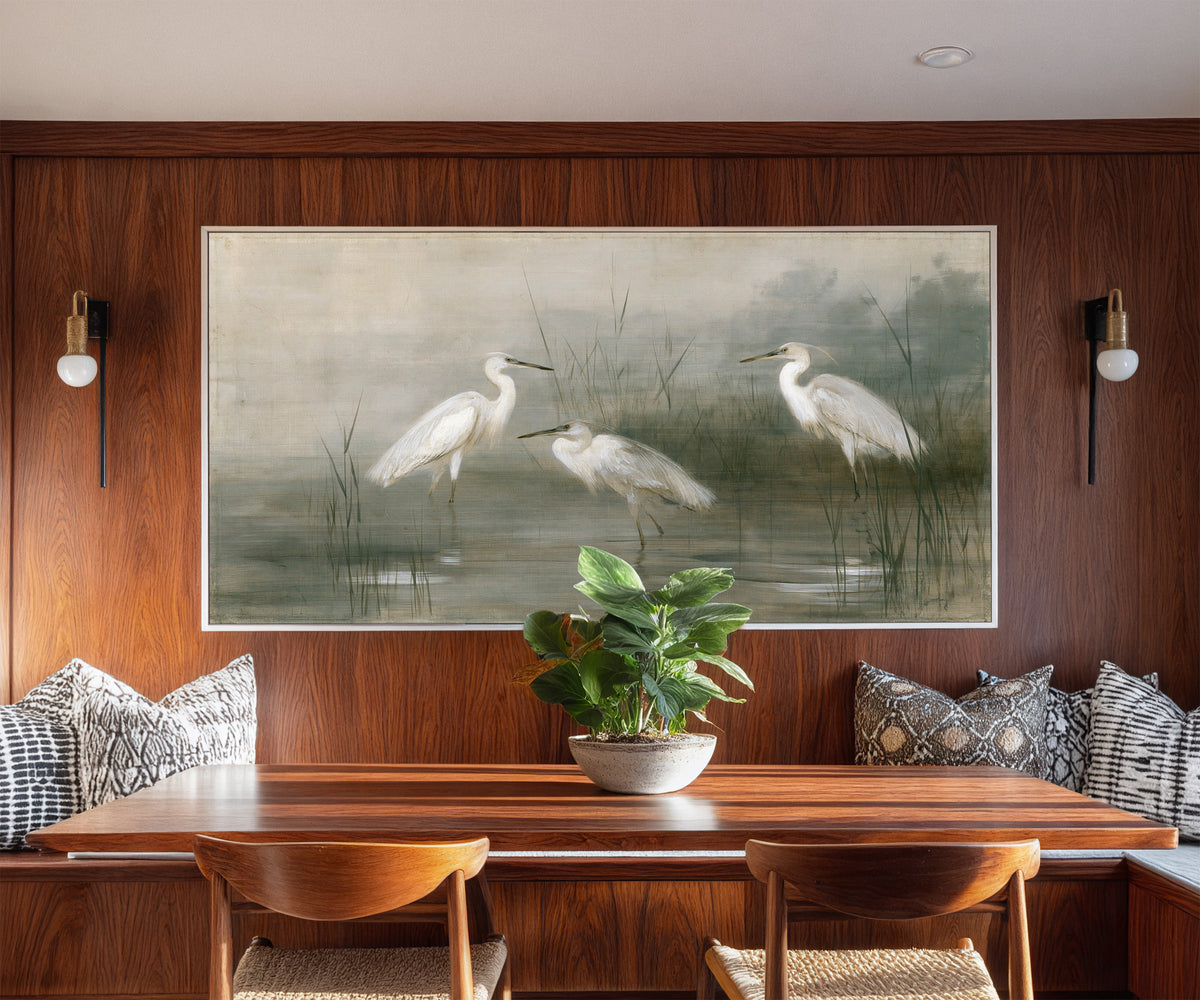 three white birds in shallow marsh water canvas wall art in a white frame in a styled room setting