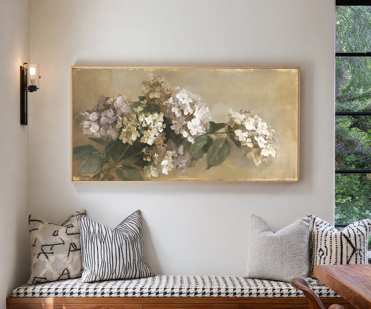 faded hydrangea cluster in cream, mauve, and canvas wall art in a natural wood frame in a living room