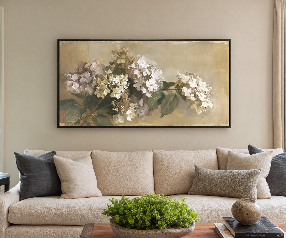 faded hydrangea cluster in cream, mauve, and canvas wall art in a black frame in a styled room setting