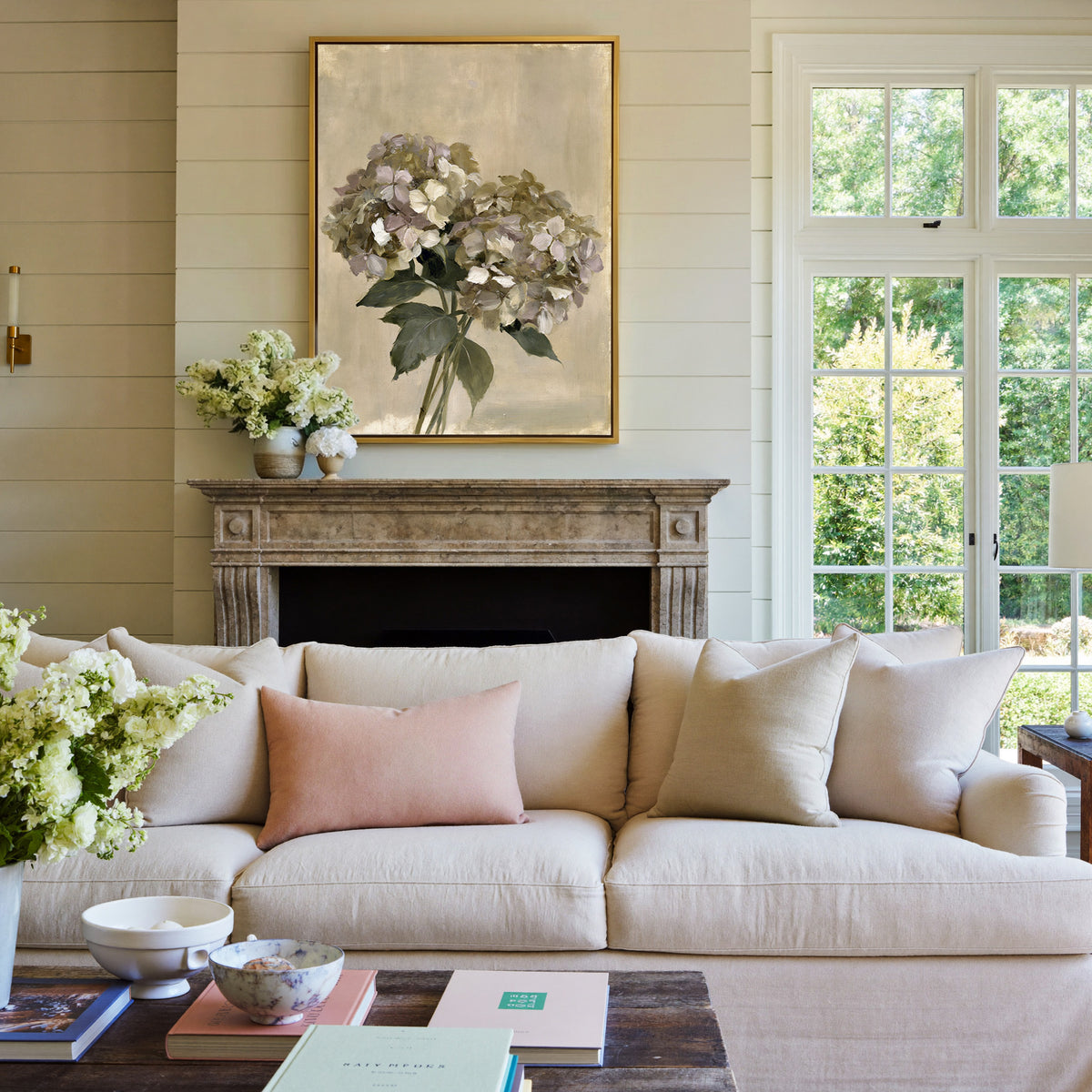 faded hydrangea cluster in cream, mauve, and canvas wall art in a gold frame above a mantel